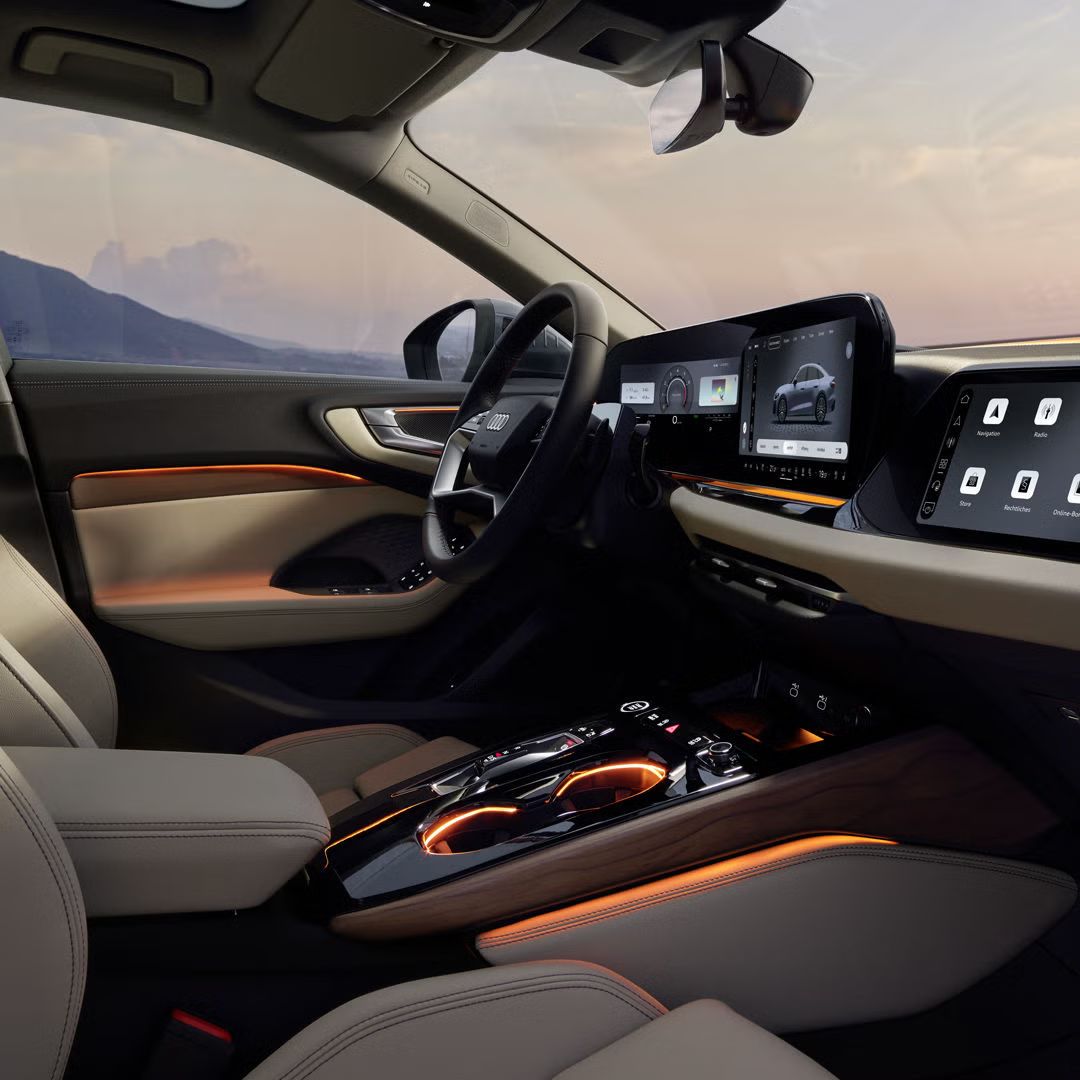 Blick in das Cockpit der A5 Limousine von der Beifahrerseite. Der Innenraum erscheint dabei in orangenem Ambiente Licht.