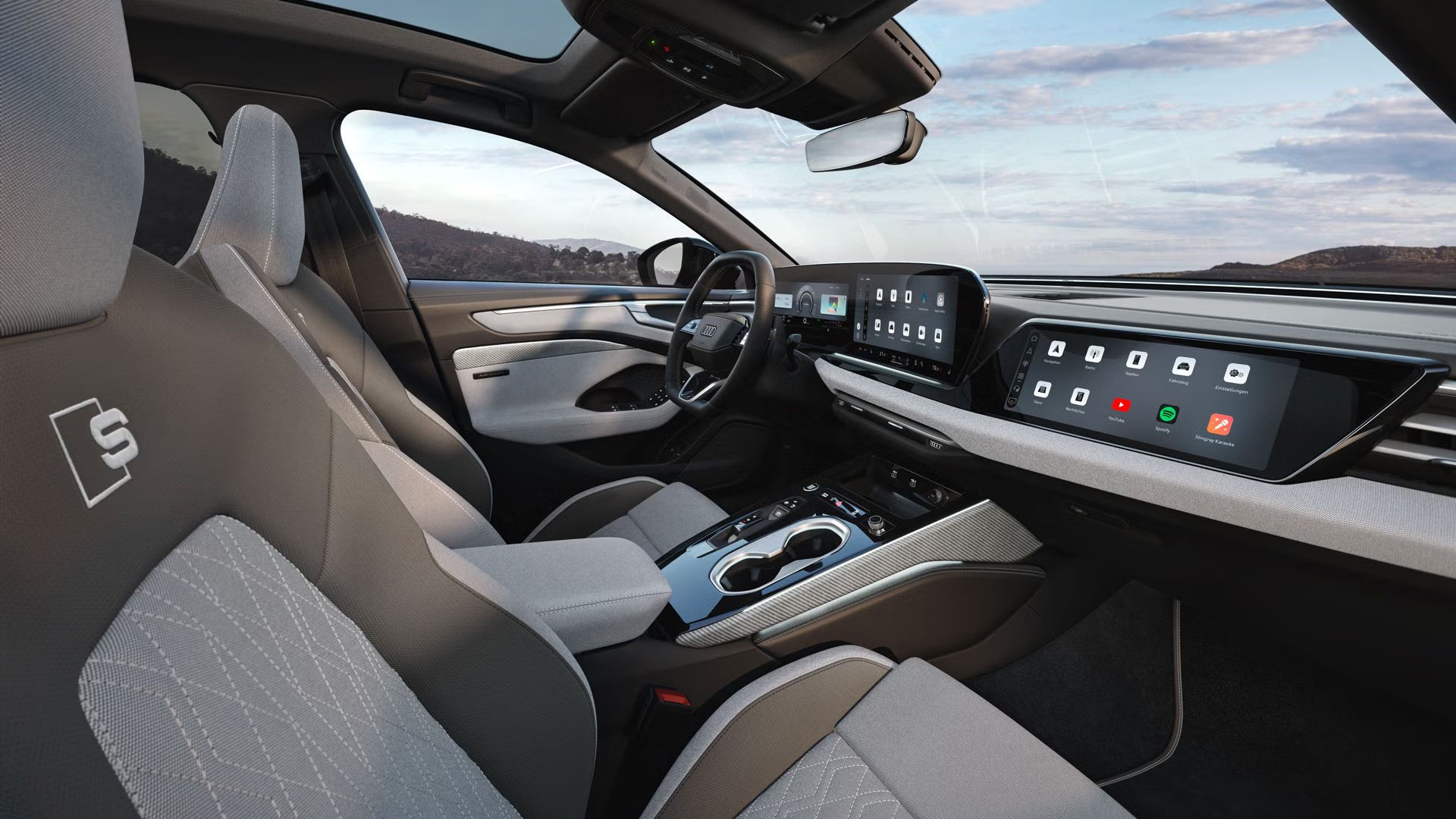 Der Innenraum der A6 Limousine e-hybrid aus der Sicht der Beifahrer B-Säule. Der Fokus liegt auf den Sportsitzen aus dem Stoff hellgrau-neodymgold mit Dekoreinlagen Leinengewebe in hellgrau.
