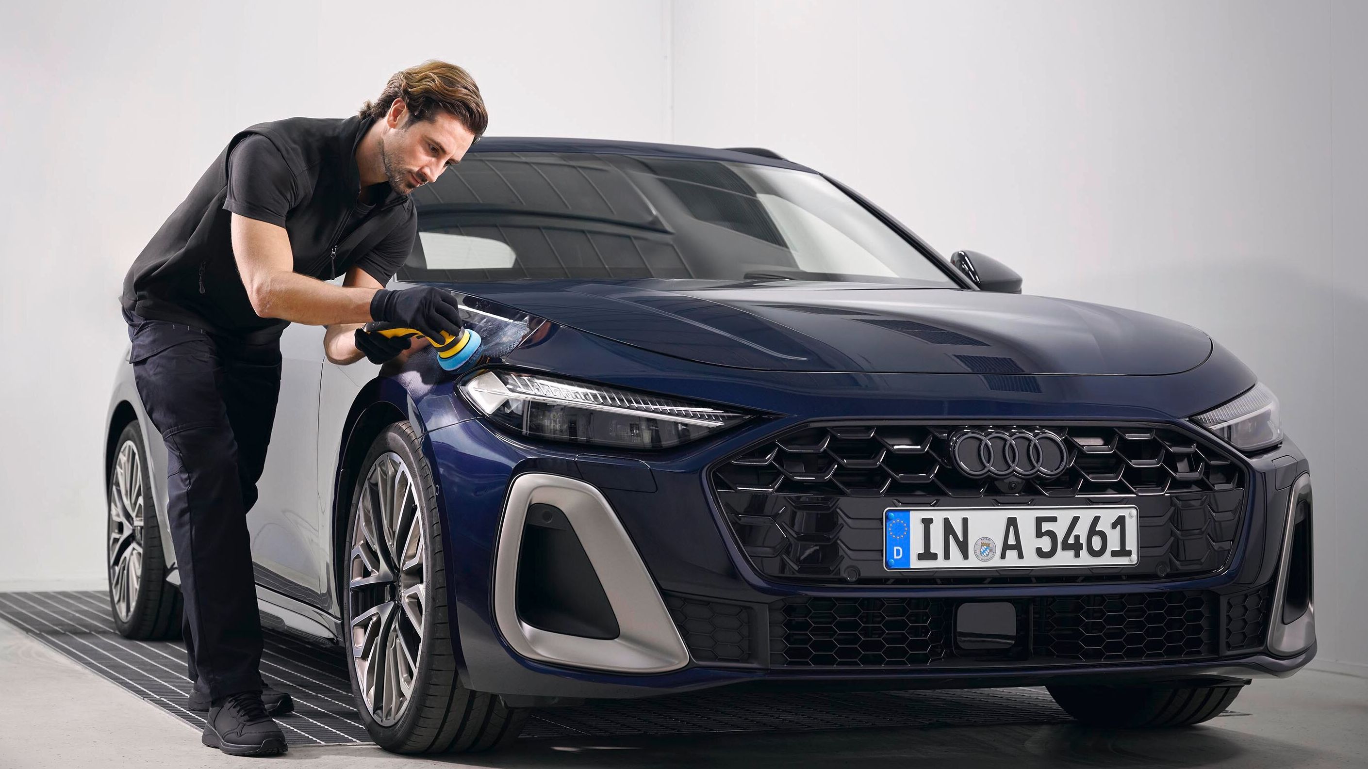 Ein Audi Techniker poliert Lack bei einem Audi