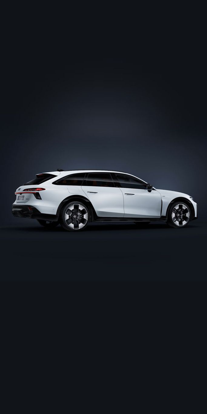 Der Audi A6 allroad e-hybrid schräg von hinten auf dunklem Hintergrund. 