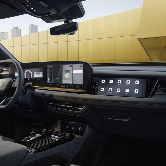 Das Cockpit und Panorama-Display aus Perspektive des Beifahrers. Der Innenraum erscheint in sonnengelbem Ambiente Licht.