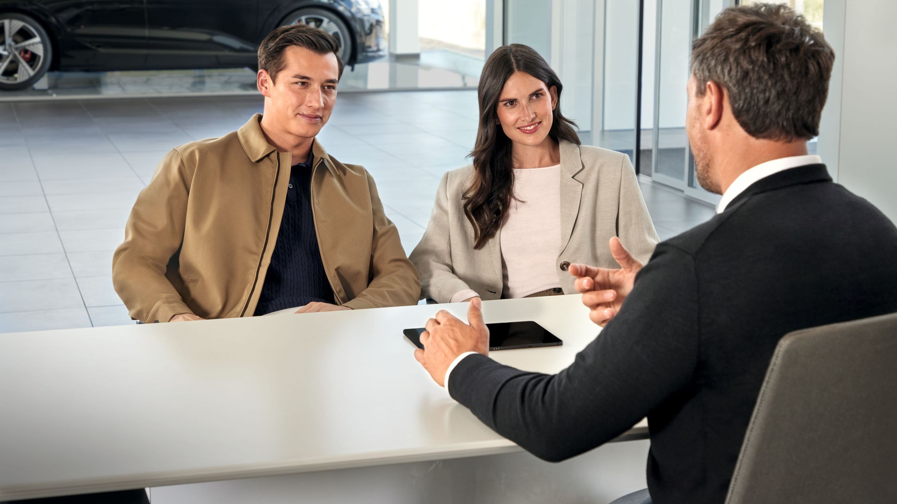 Ein Audi Service Mitarbeiter im Gespräch mit Kunden.