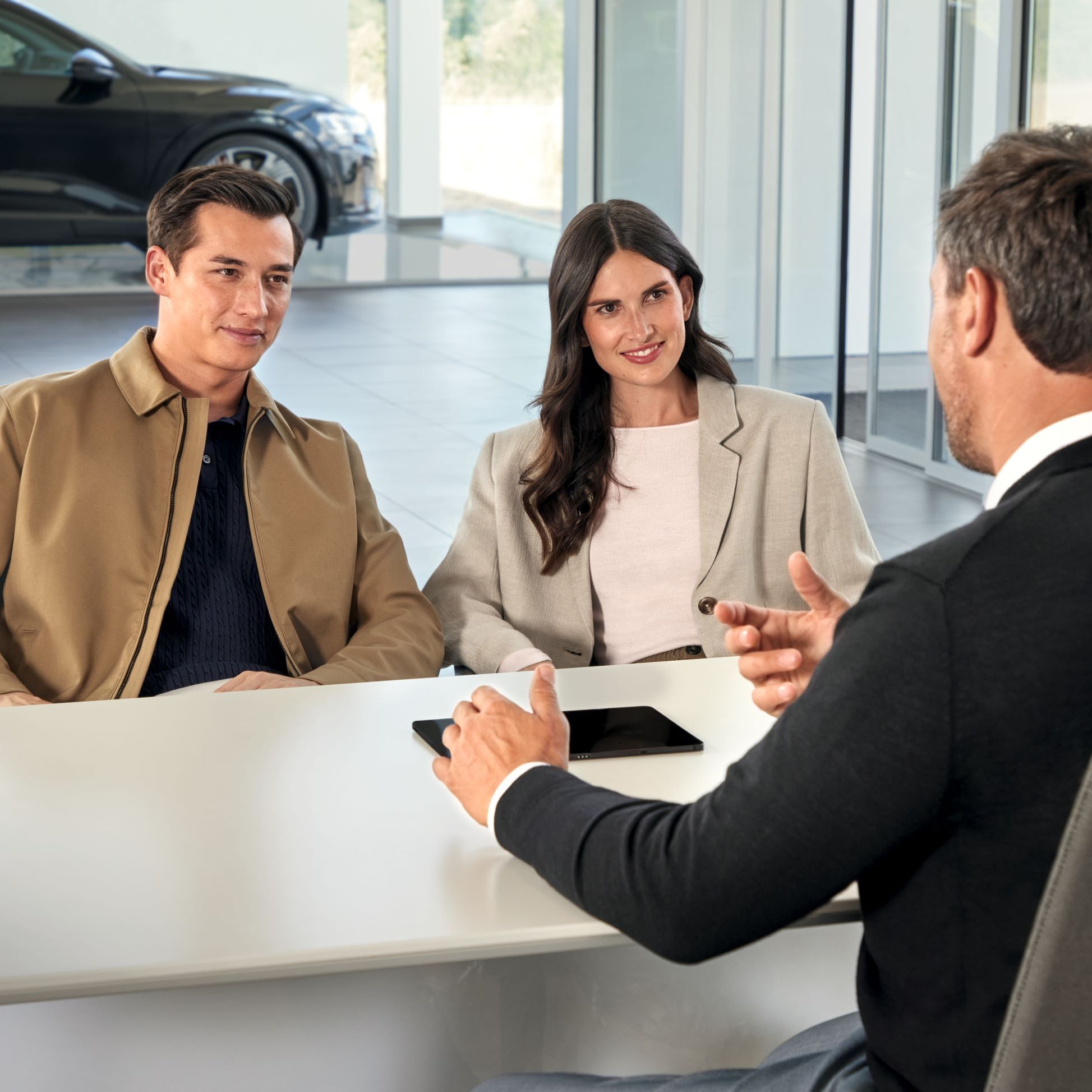 Ein Audi Service Mitarbeiter im Gespräch mit Kunden.
