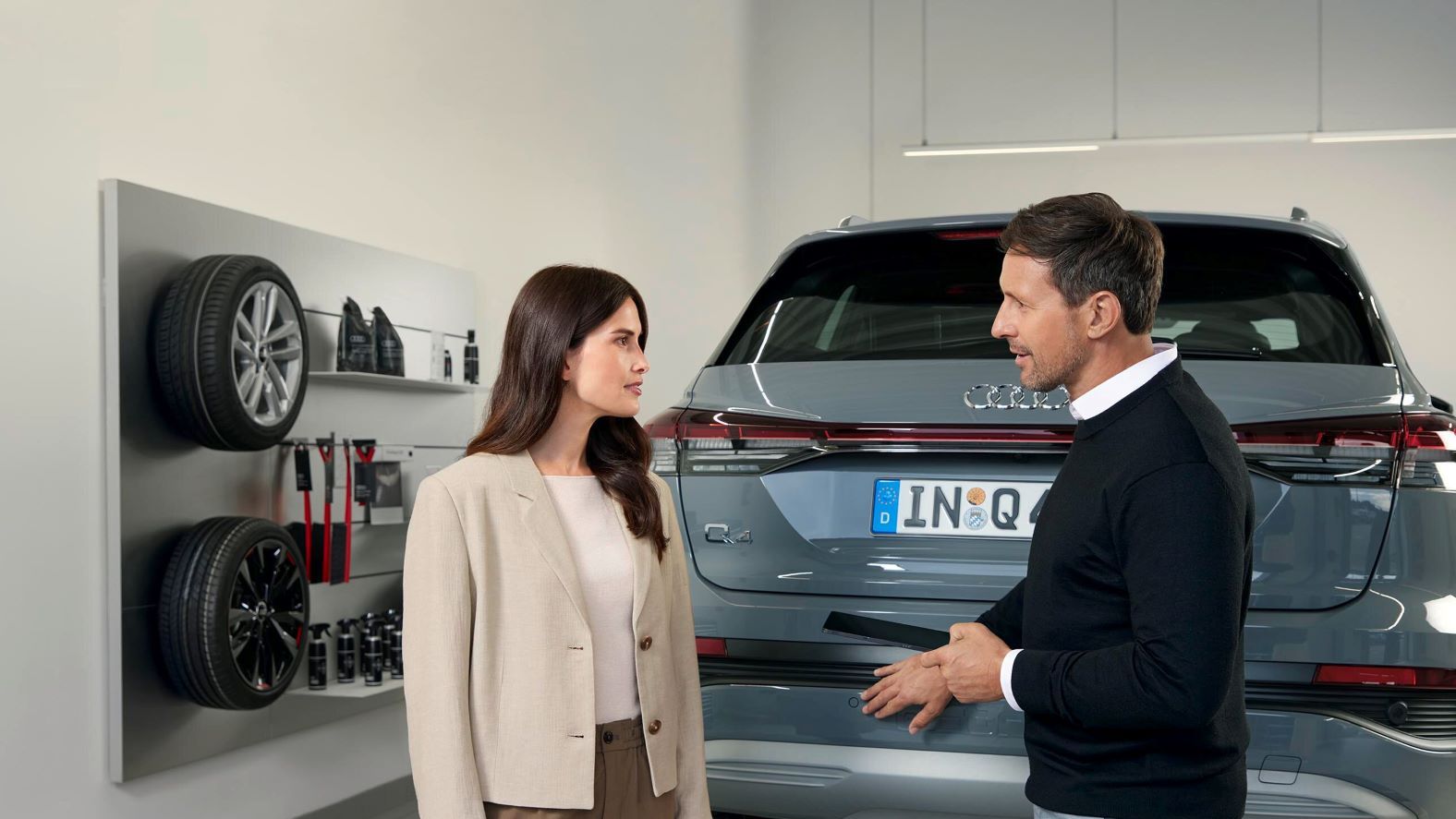 Ein Audi Service Mitarbeiter im Gespräch mit einer Kundin.