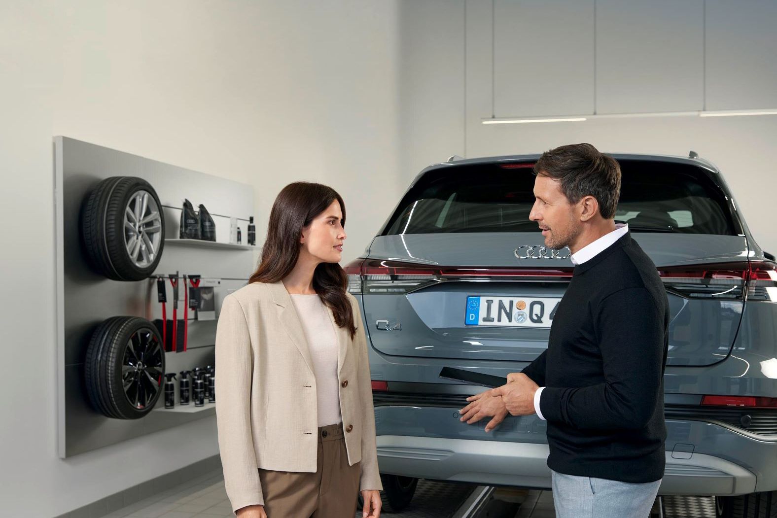 Ein Audi Service Mitarbeiter im Gespräch mit einer Kundin.