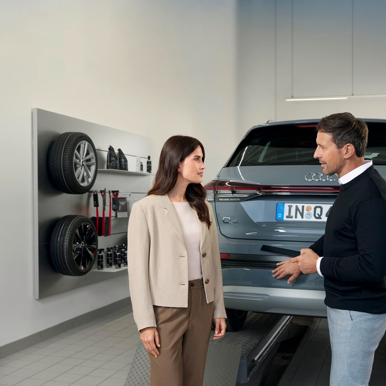 Ein Audi Service Mitarbeiter im Gespräch mit einer Kundin.