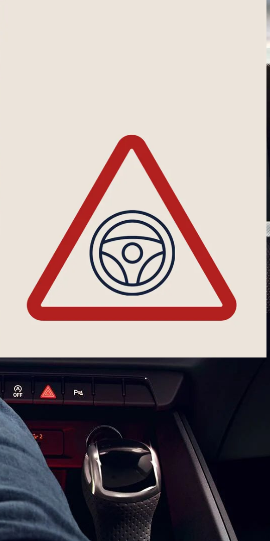 Innenansicht eines Audi-Cockpits, bei dem eine Hand das Lenkrad hält und das digitale Armaturenbrett mit Tacho und weiteren Anzeigen zu sehen ist. Rechts im Bild ist ein eingeblendetes dreieckiges Warnsymbol mit einem Lenkrad-Piktogramm.