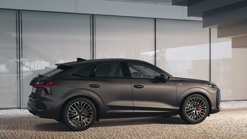 Der Audi Q3 Sportback steht unter einer Treppe. Das Auto ist von der Seite zu erkennen und es zeigt die genauen Details der Außenseite.