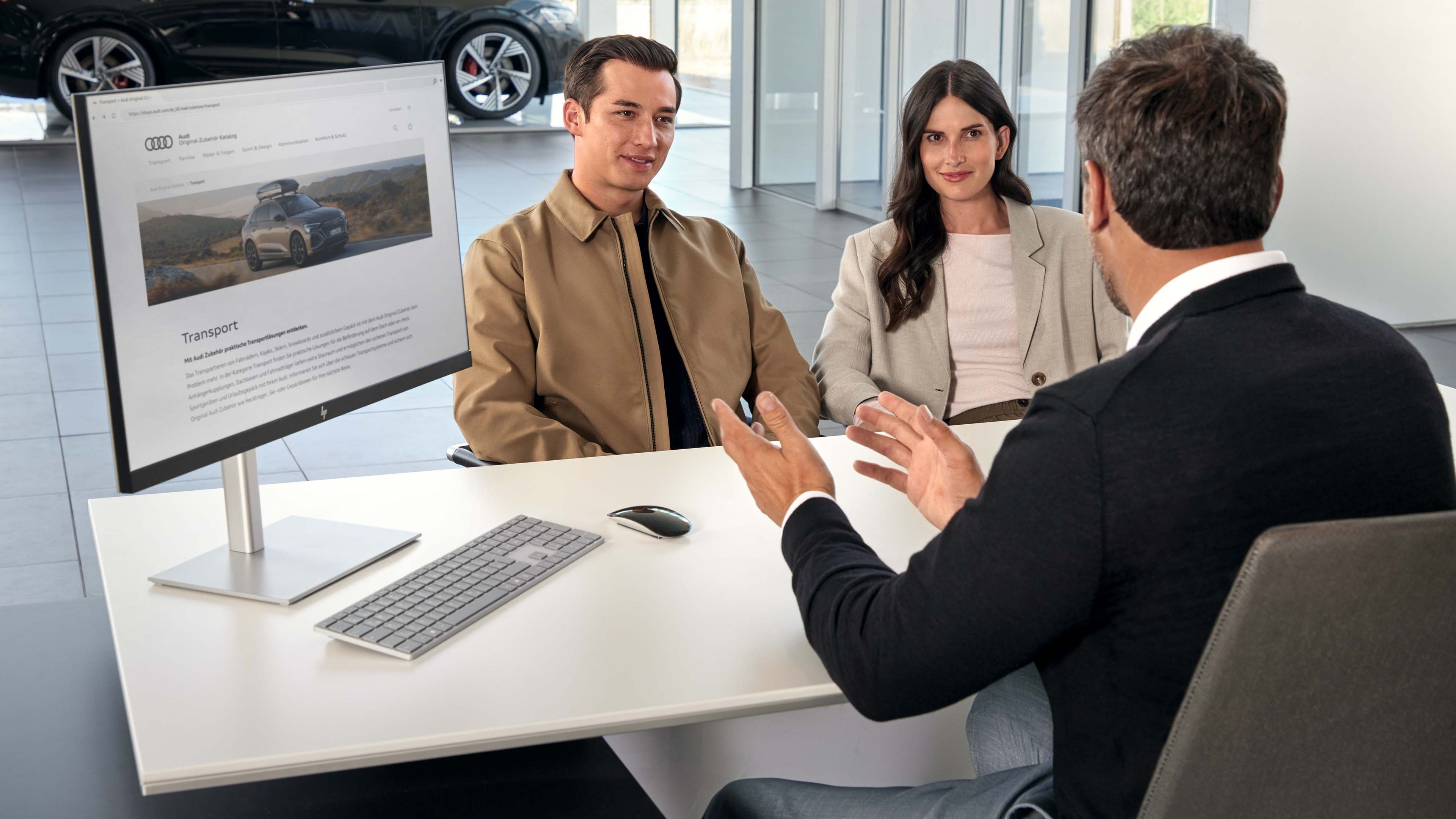 Serviceberater mit Kunden vor einem Monitor, Bildschirm mit Anzeige