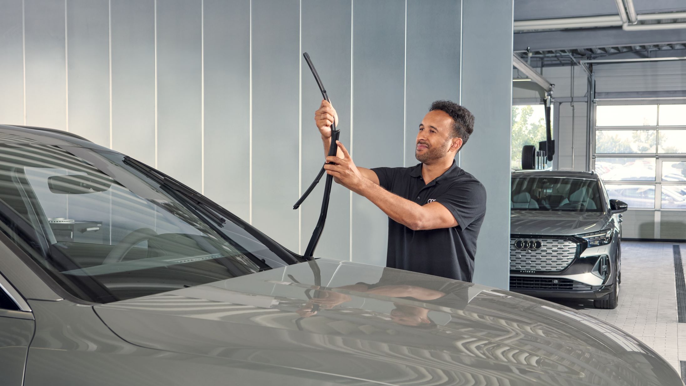 Ein Audi Techniker wechselt Wischerblätter bei einem Audi.