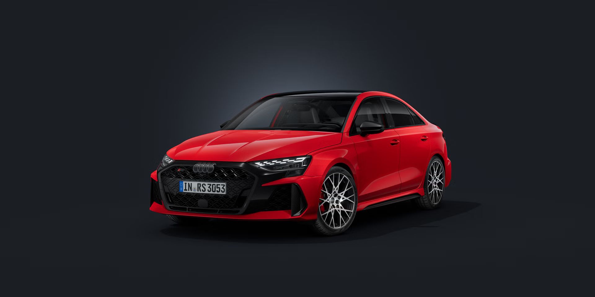 Die Audi RS 3 Limousine schräg von vorn auf dunklem Hintergrund.