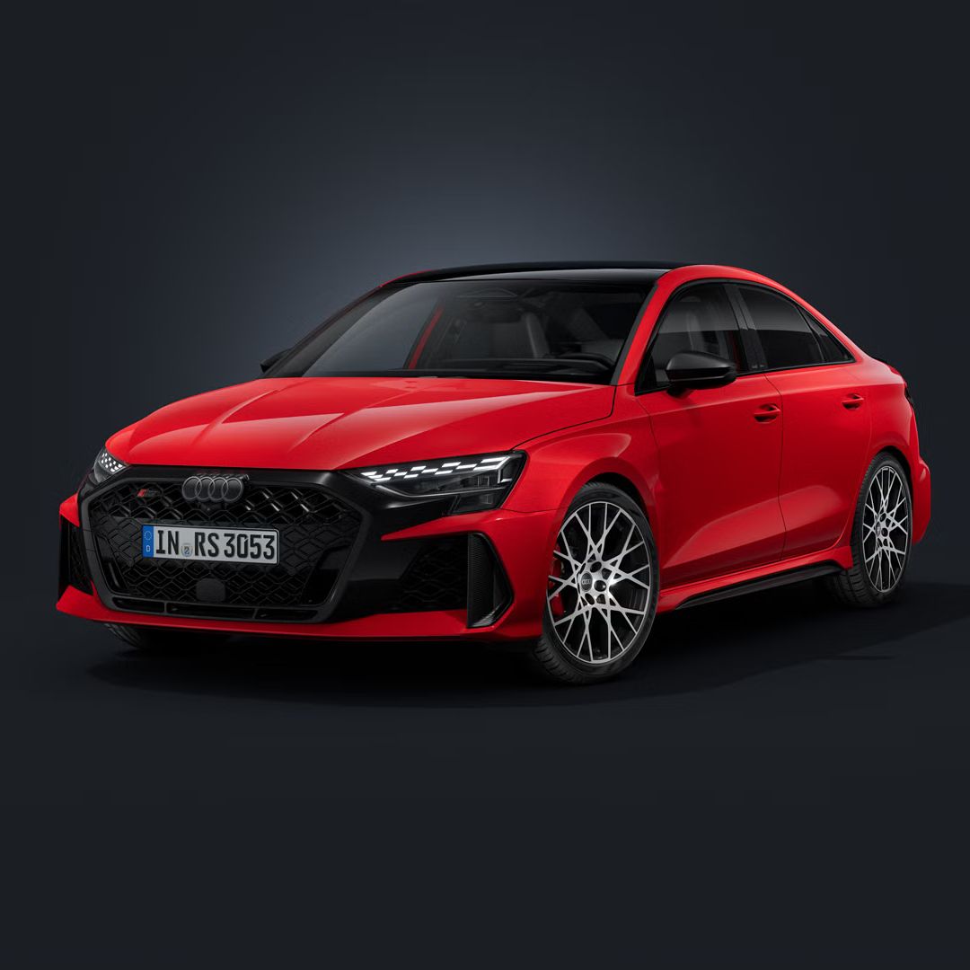 Die Audi RS 3 Limousine schräg von vorn auf dunklem Hintergrund.