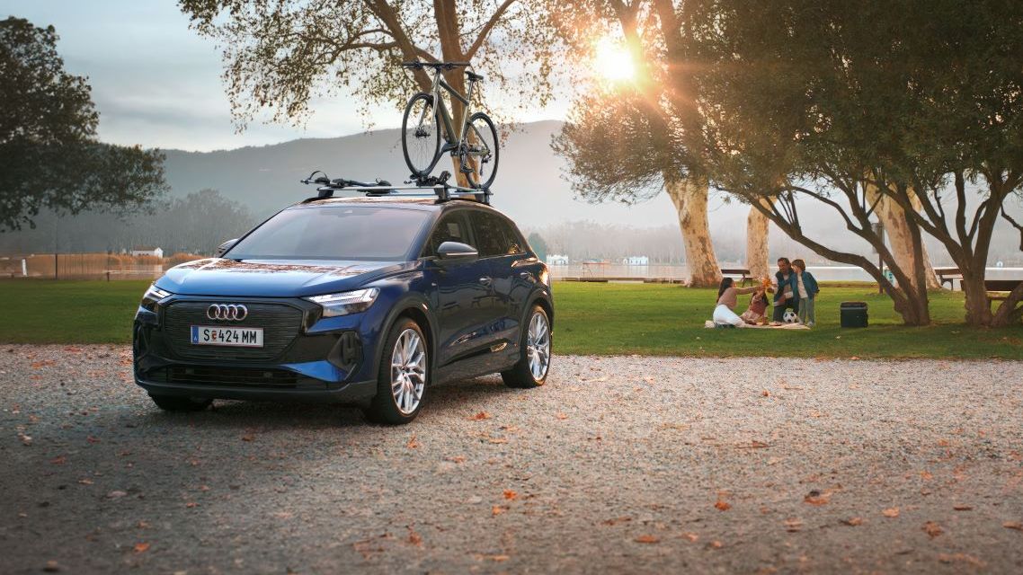 Ein blauer Audi mit Fahrradträger und Fahrrad auf dem Dach.