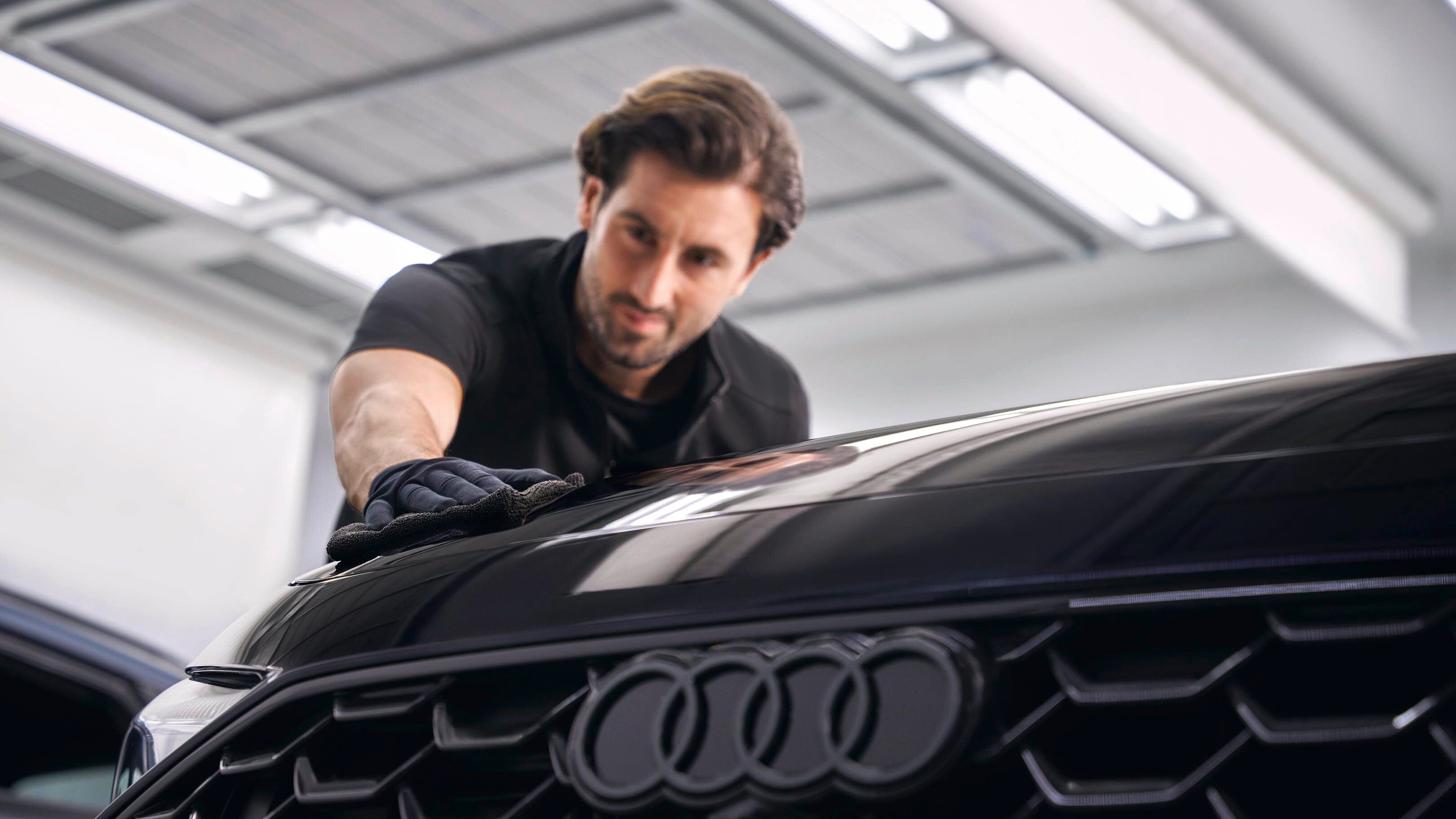 Ein Audi Techniker poliert Lack bei einem Audi