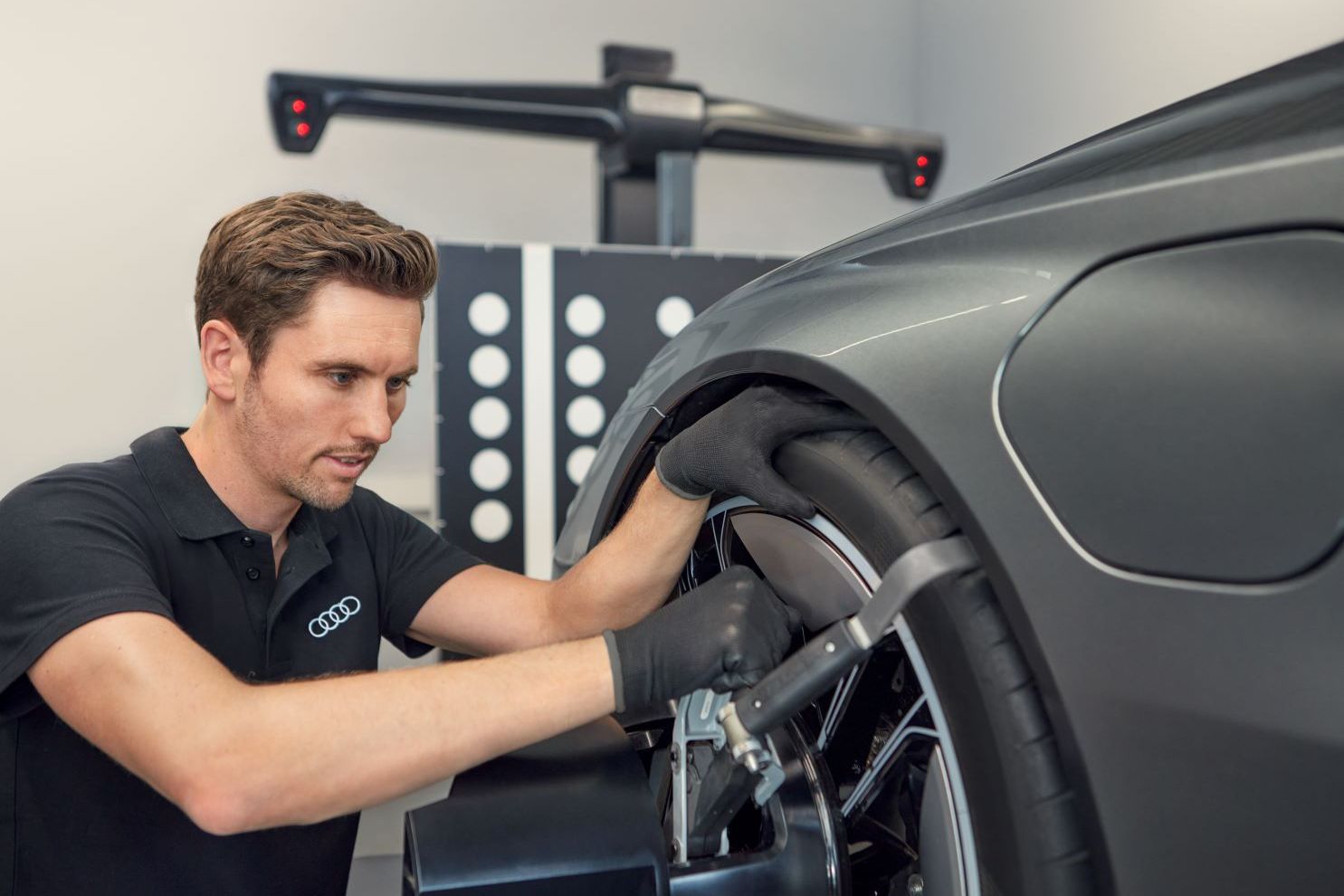Ein Audi Mechaniker montiert neue Räder an einem Audi