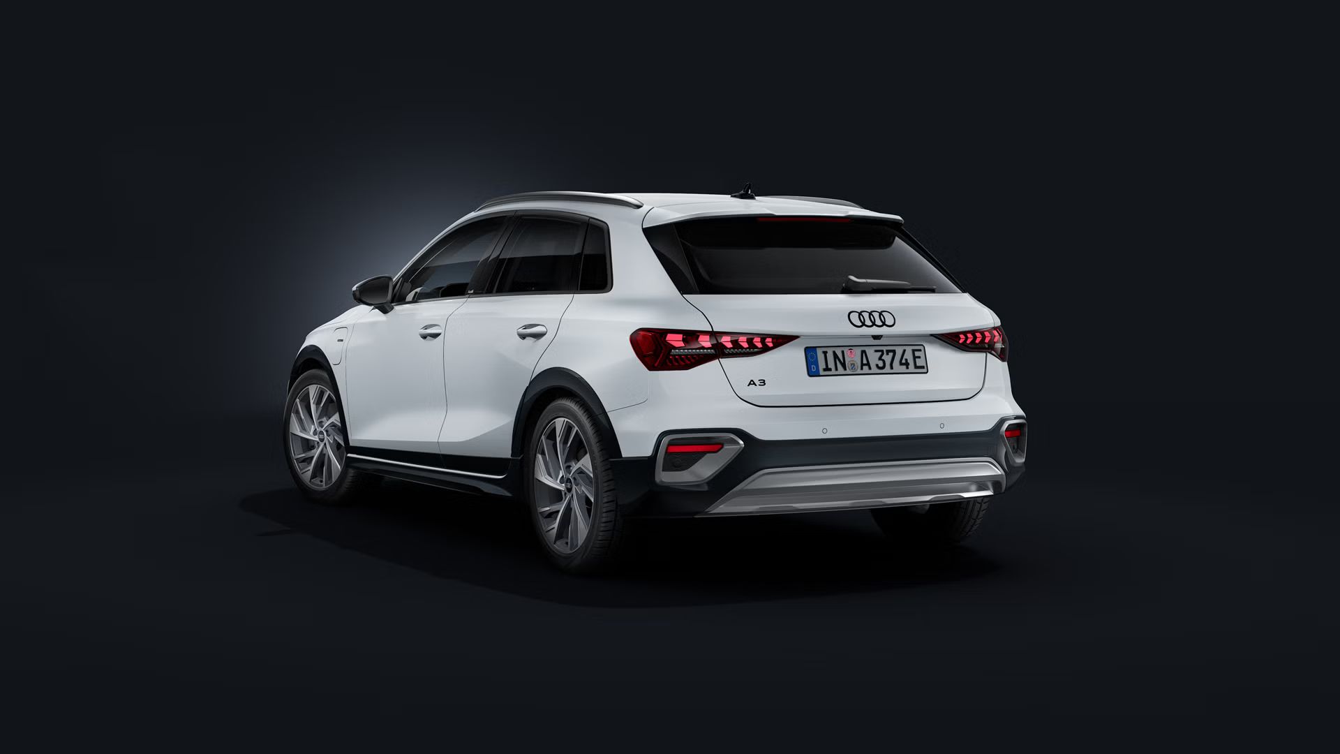 Der Audi A3 allstreet e-hybrid schräg von hinten auf dunklem Hintergrund.
