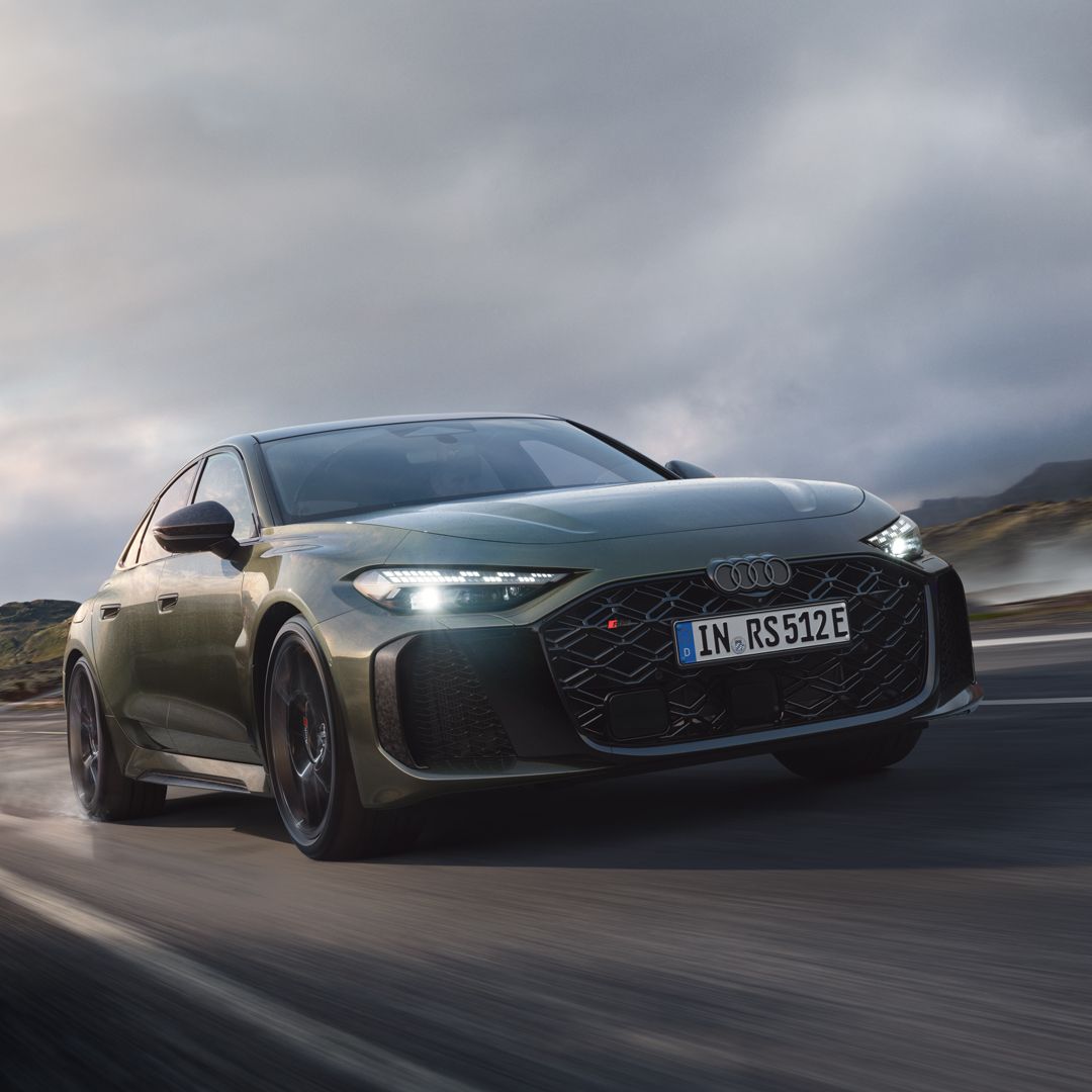 Die RS 5 Limousine schräg von vorn fährt auf einer Gebirgsstraße. Wasserdampf steigt links und rechts auf.