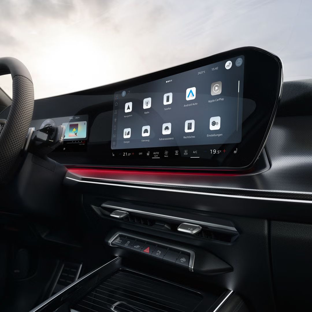 Das Interior des Q3 Sportback e-hybrid mit Lenkrad, Panoramadisplay und rotem Ambiente-Lichtpaket.	