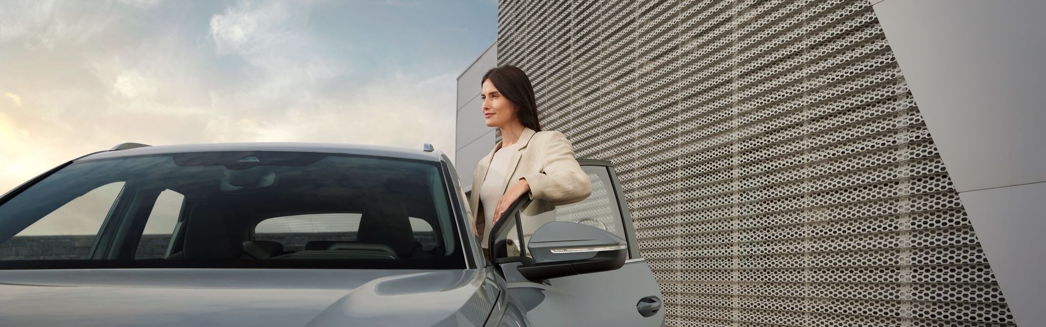 Eine Frau steigt in ihren Audi Q4 ein.