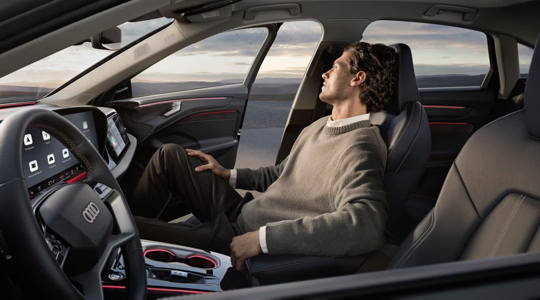 Ein Mann sitzt auf dem Beifahrersitz in einer Audi A6 Limousine