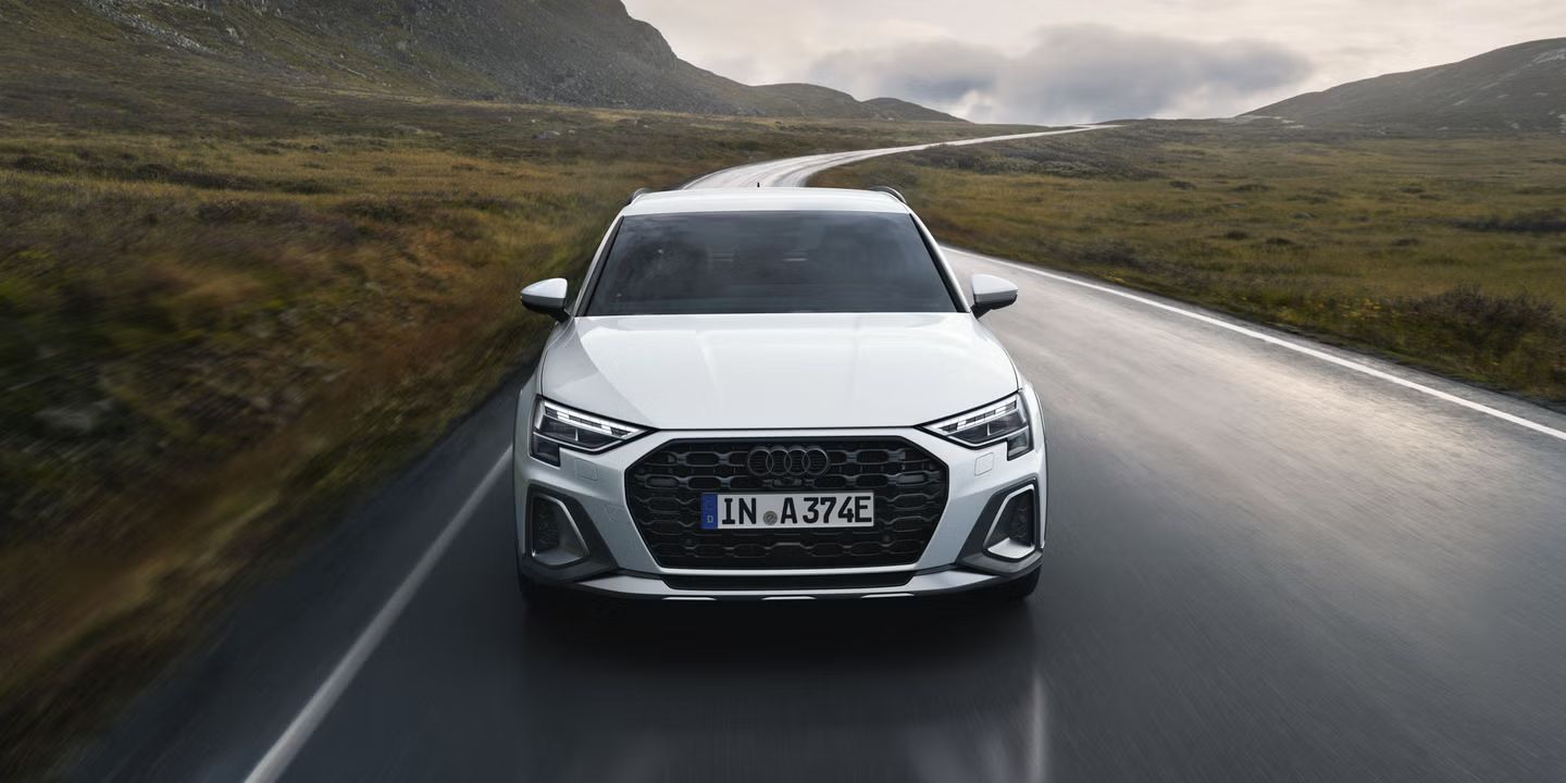 Der Audi A3 allstreet e-hybrid frontal von vorn auf einer Gebirgsstraße.