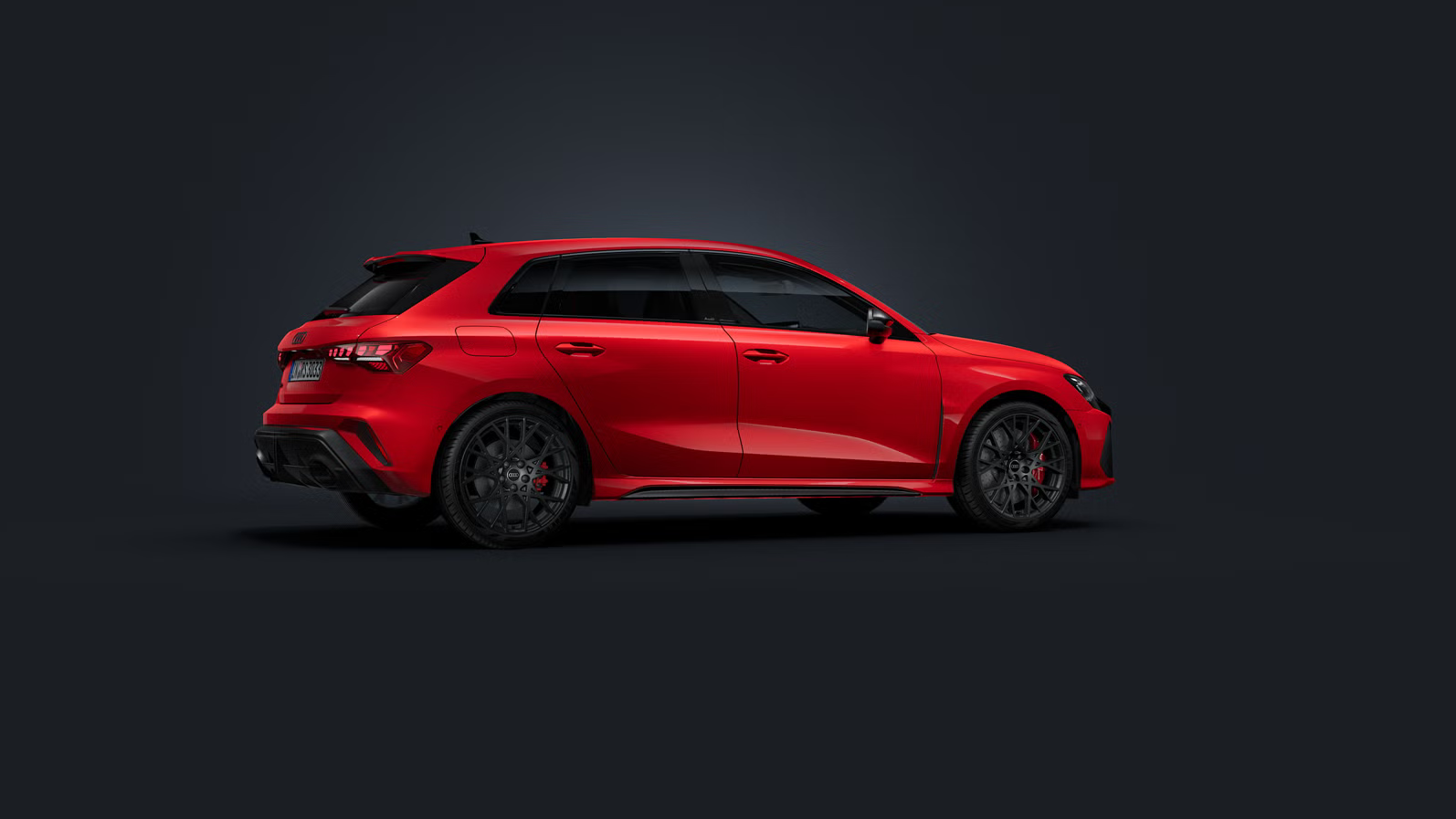 Der Audi RS 3 Sportback steht auf dunklem Hintergrund und dreht sich leicht auf die rechte Seite.