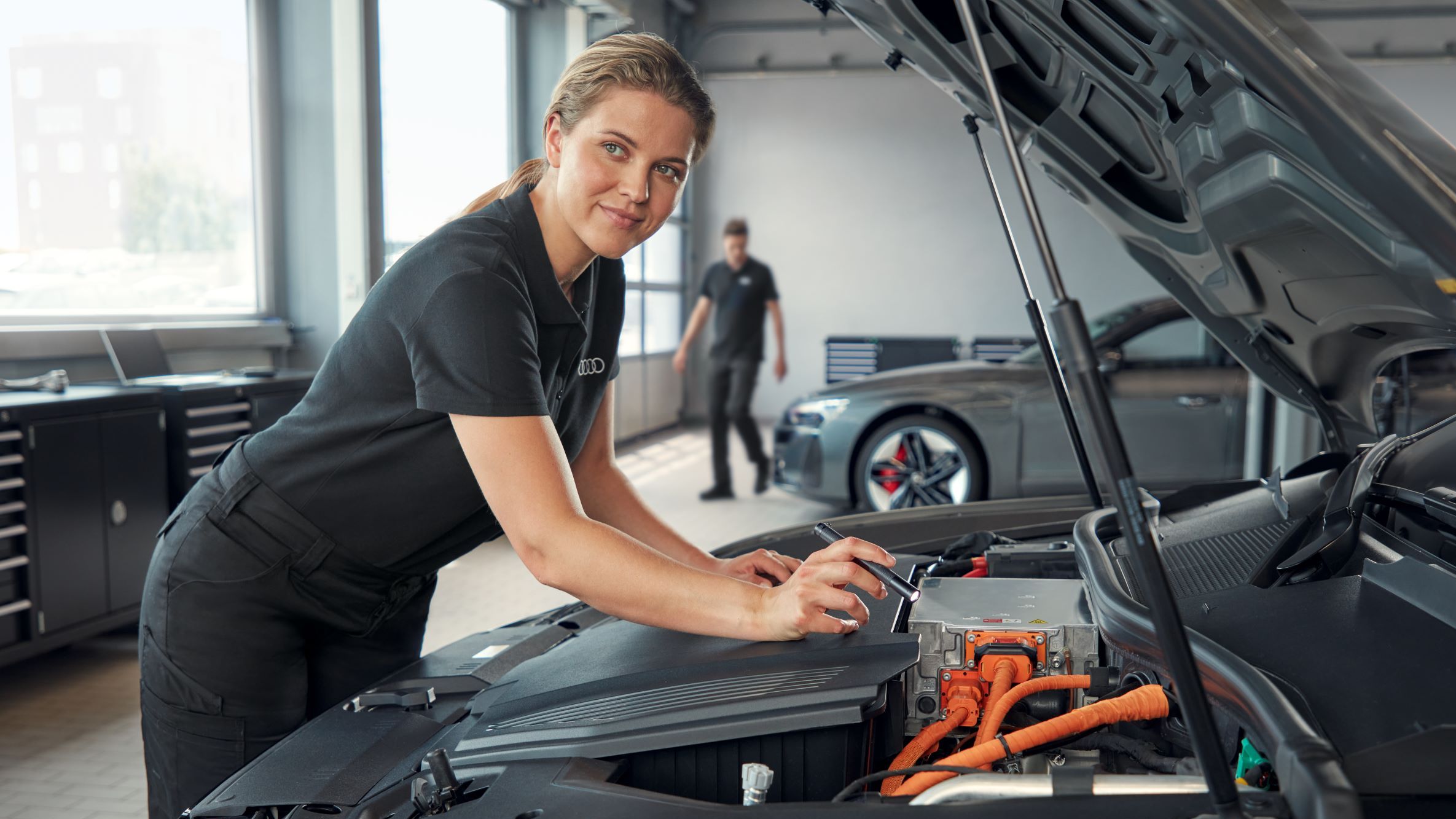 Eine Audi Mechanikerin beim Check der Klimaanlage.