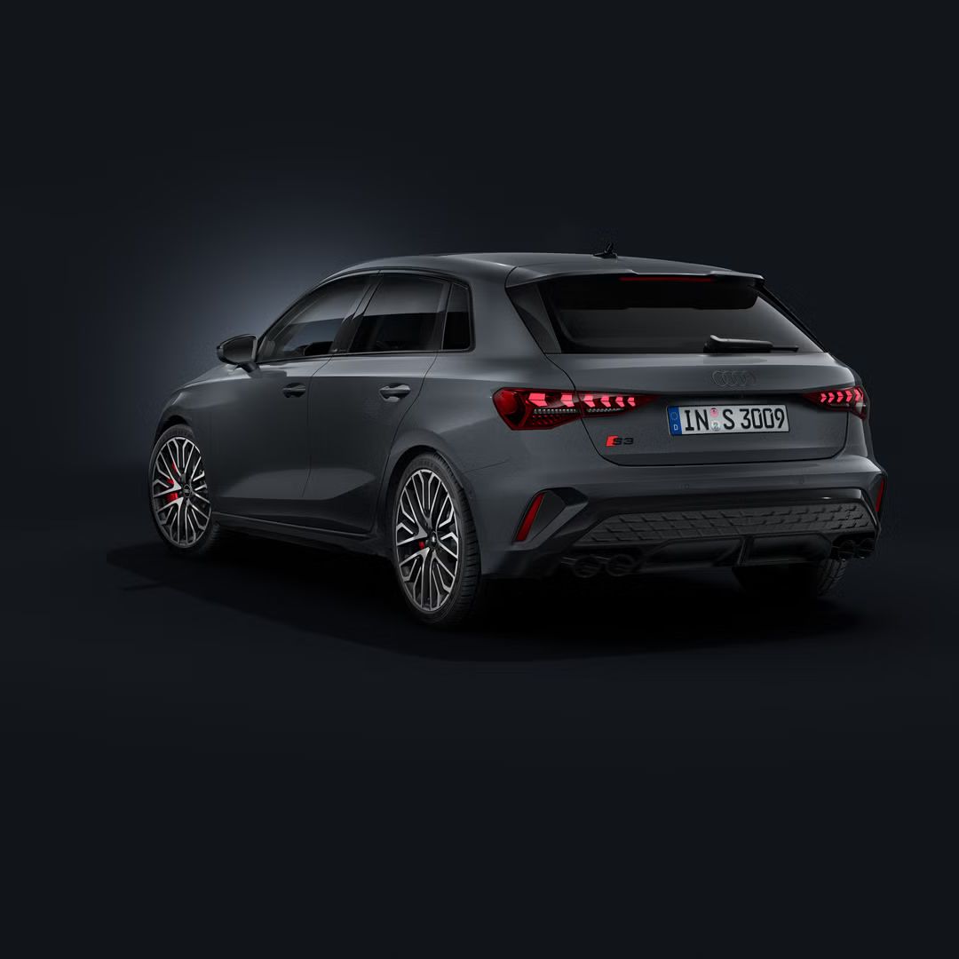 Der Audi S3 Sportback schräg von hinten auf dunklem Hintergrund.