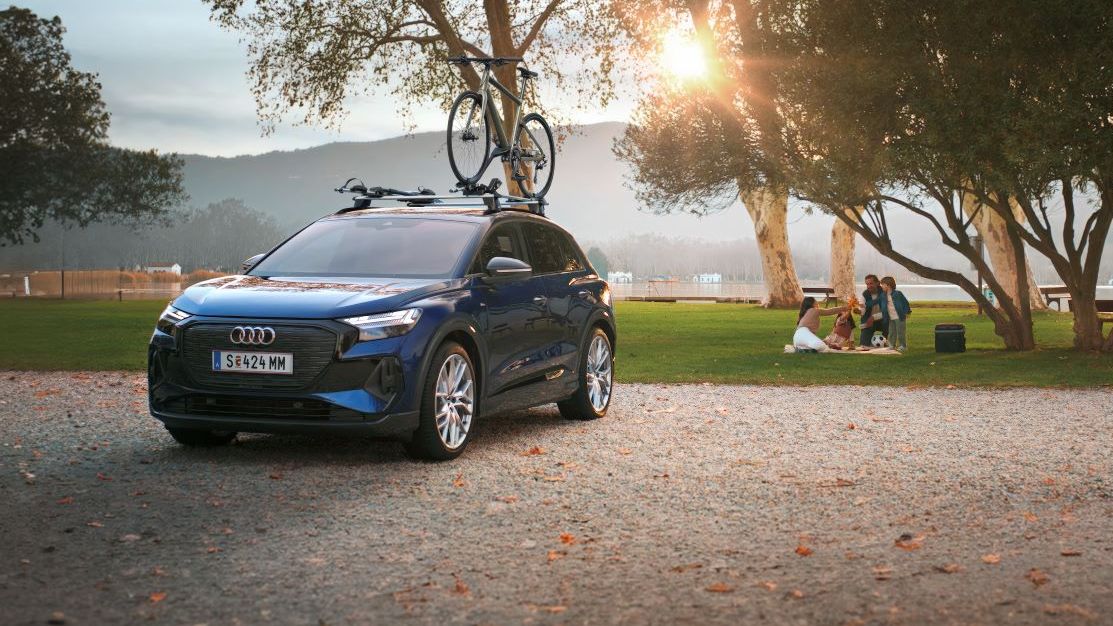 Ein blauer Audi mit Fahrradträger und Fahrrad auf dem Dach.