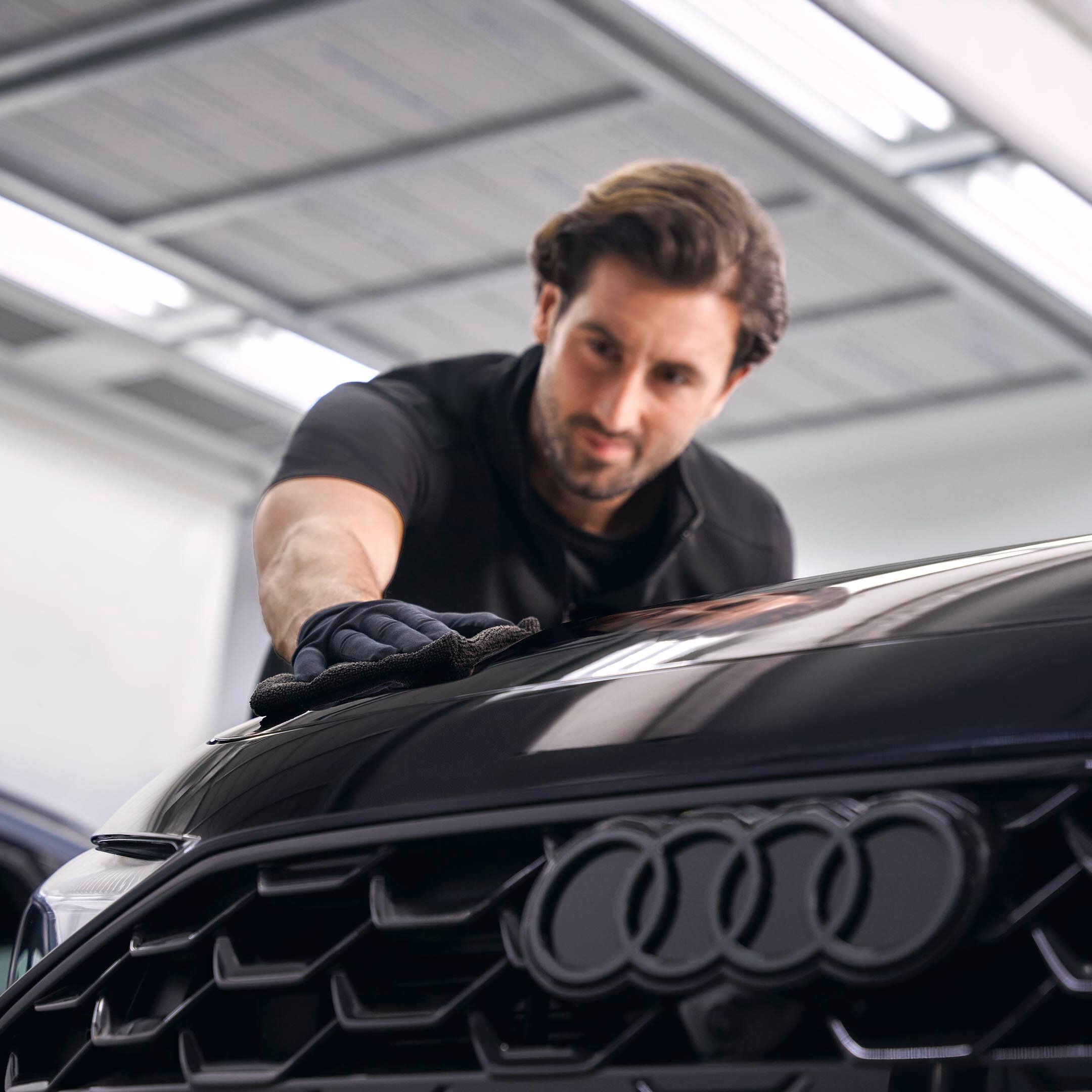 Ein Audi Techniker poliert Lack bei einem Audi