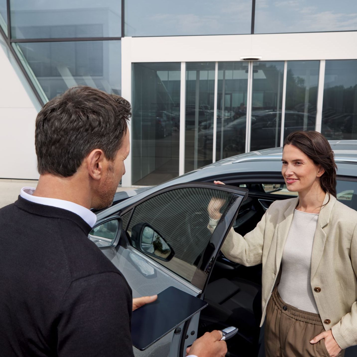 Frau erhält Informationen und Schlüssel zu einem Audi von einem Audi Mitarbeiter.