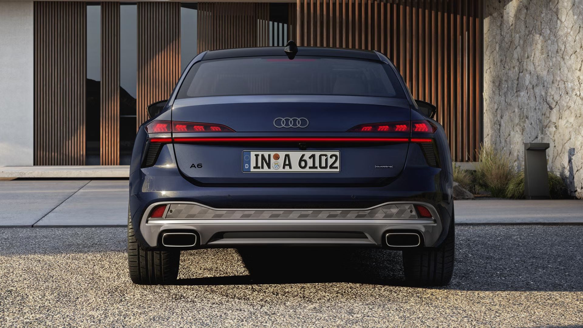 Die A6 Limousine in der Heckperspektive. Das Fahrzeug steht einem modernen Haus zugewandt.