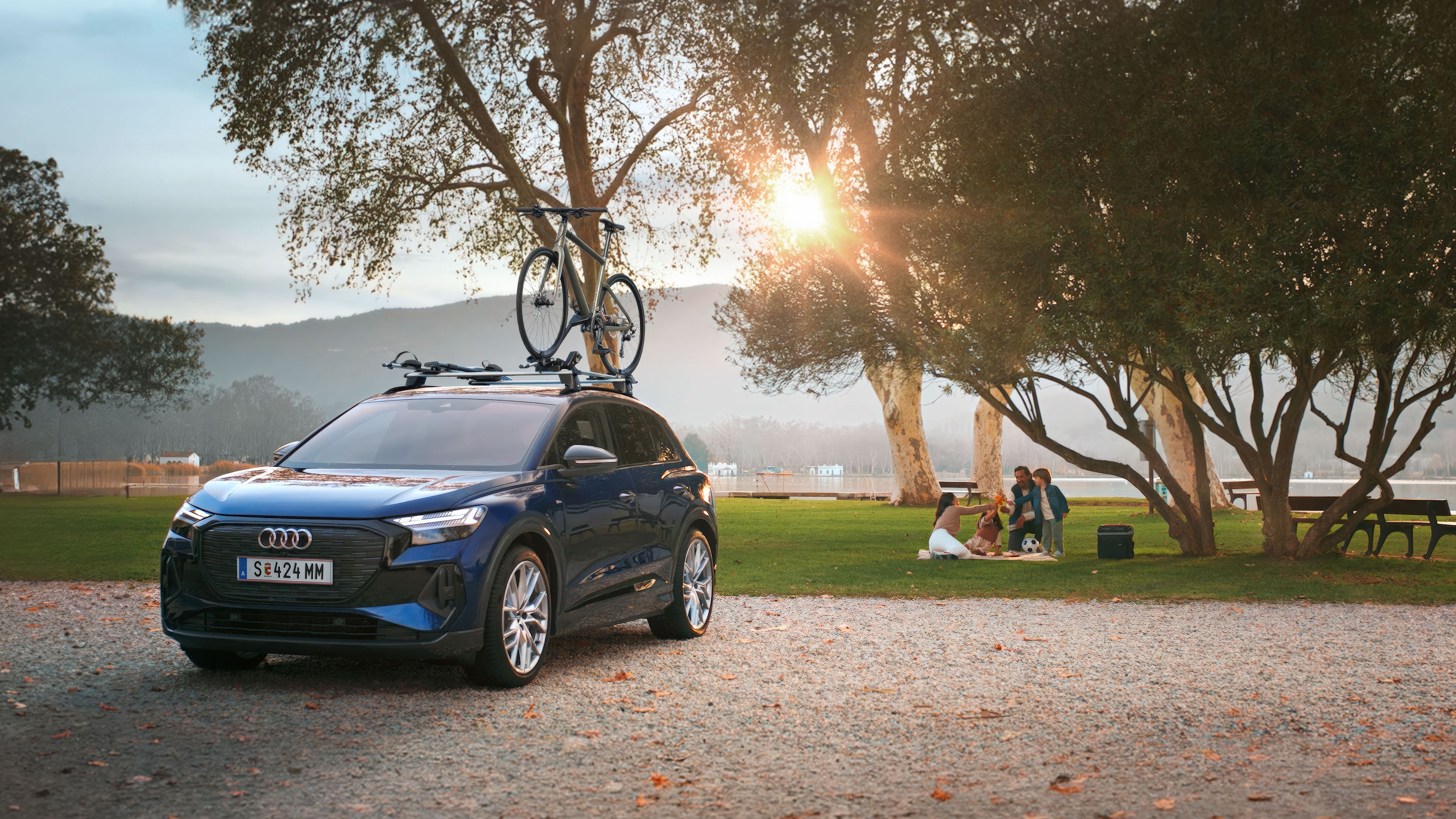 Ein blauer Audi mit Fahrradträger und Fahrrad auf dem Dach.