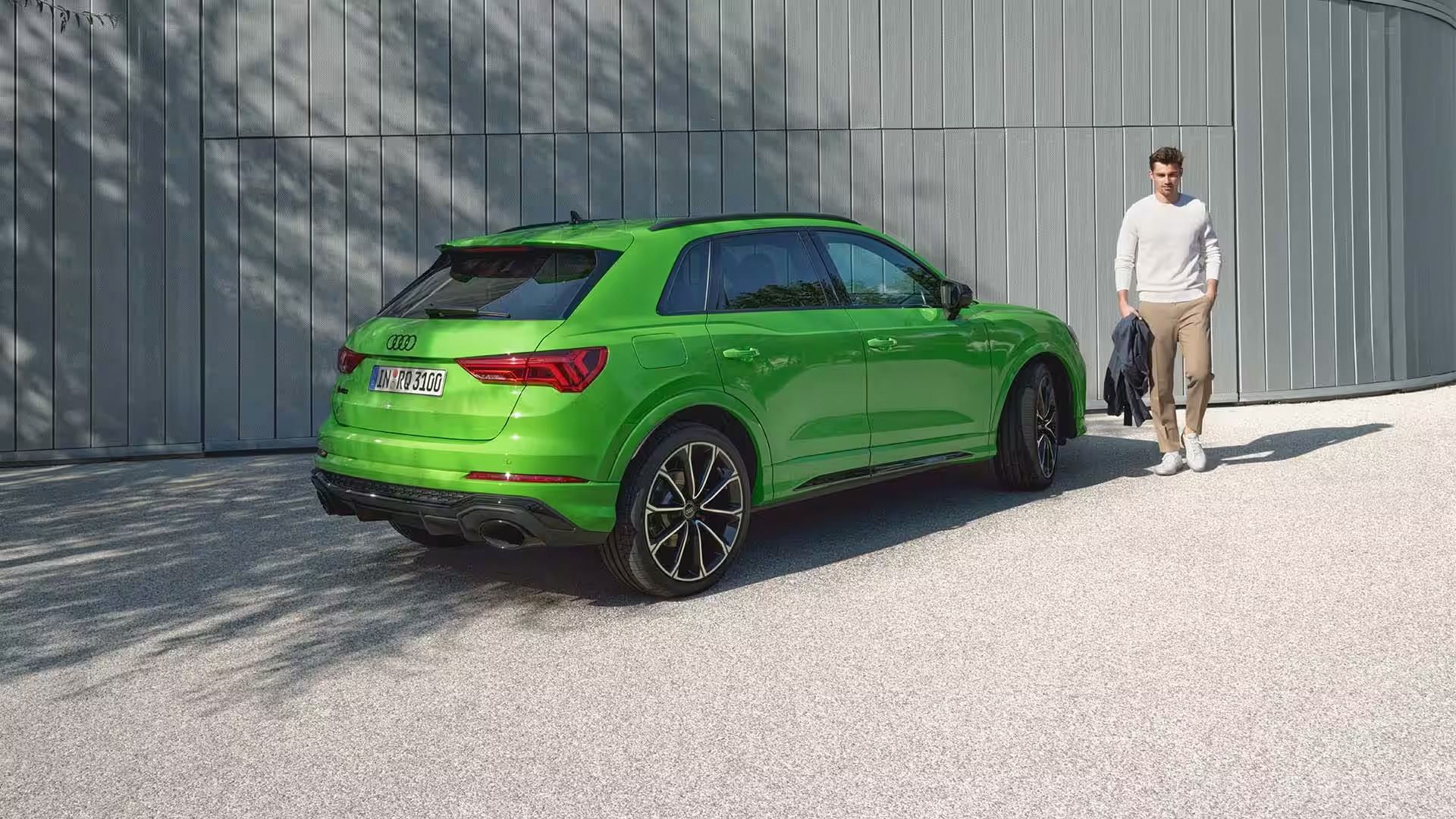 Audi RS Q3 Seitliche Heckansicht mit Model an der Seite