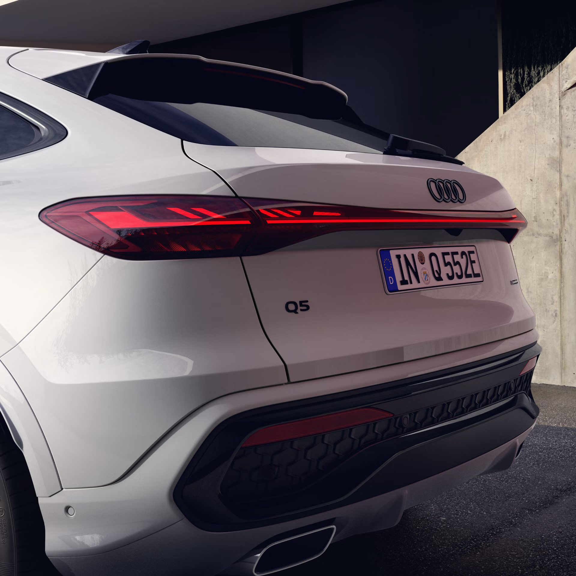 Der Q5 Sportback e-hybrid mit Nahaufnahme auf die linke Heckleuchte und die Schlusslichtsignatur via OLED-Technologie.