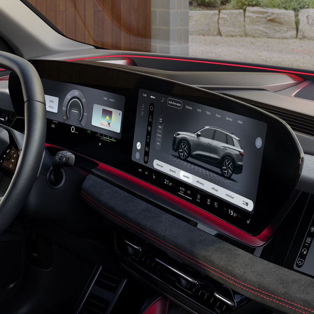 Das Cockpit und Panorama-Display aus Perspektive des Beifahrers. Der Innenraum erscheint in rotem Ambiente Licht.