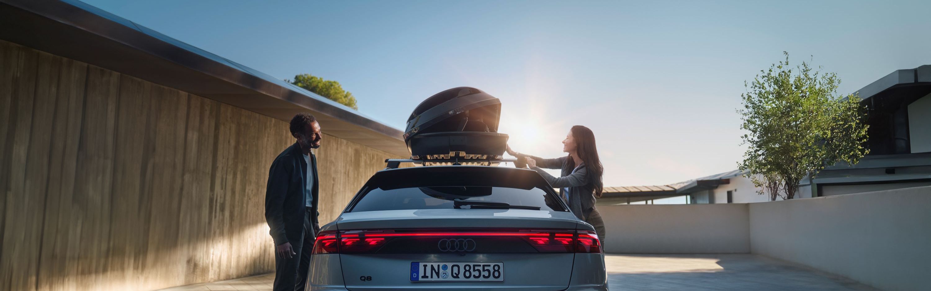 Ein Audi Q8 mit geöffneter Dachbox auf dem Dach.