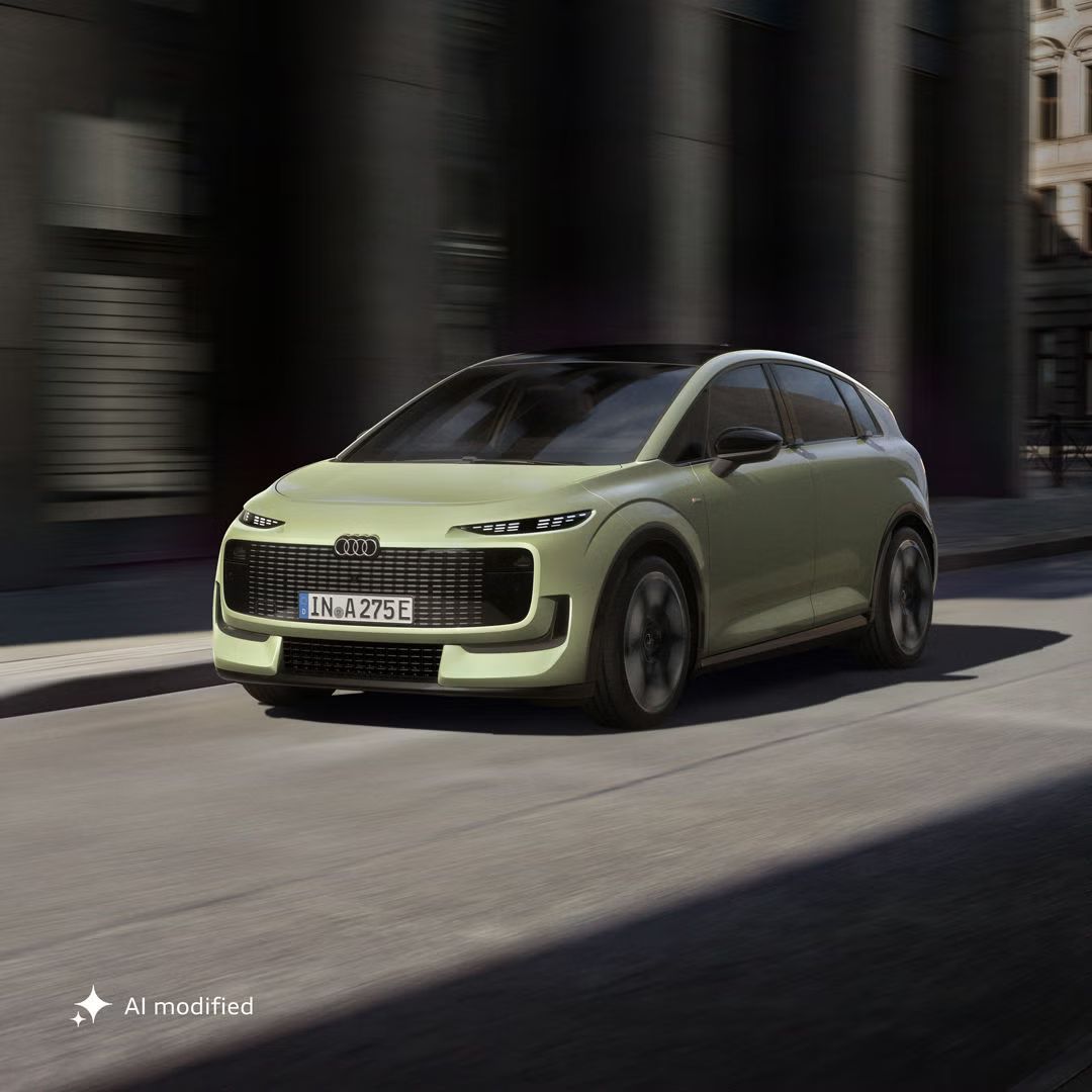 Der Audi A2 e-tron schräg von vorne auf einer schmalen Straße in urbaner Umgebung.