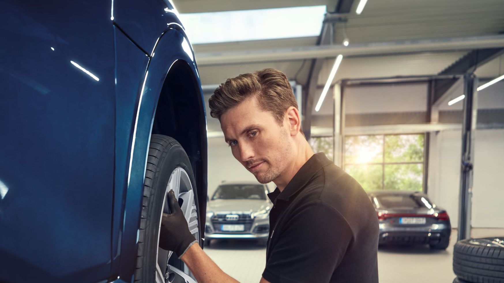 Ein Audi Mechaniker beim Räderwechsel