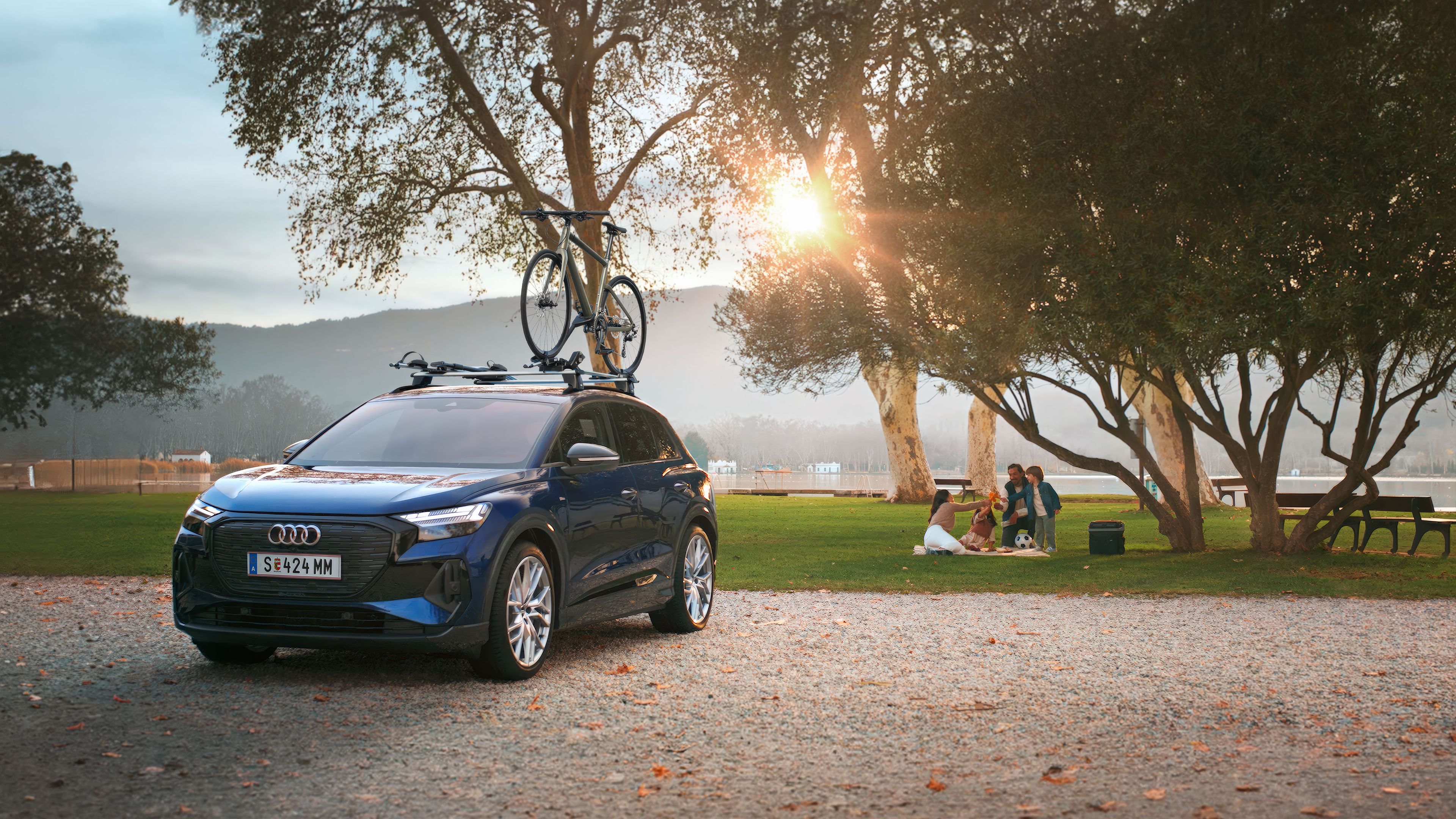 Ein blauer Audi mit Fahrradträger und Fahrrad auf dem Dach.