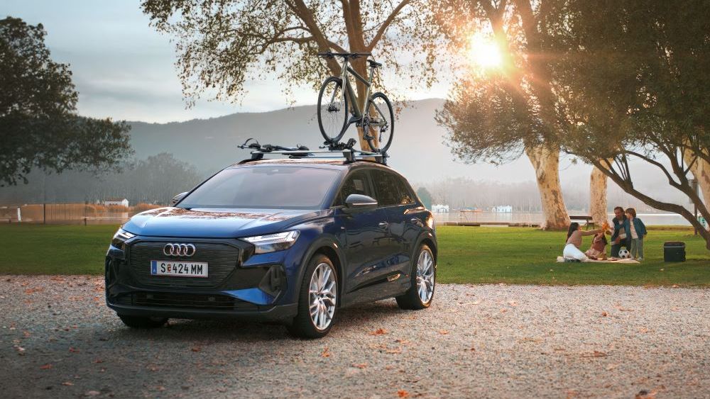 Ein blauer Audi mit Fahrradträger und Fahrrad auf dem Dach.