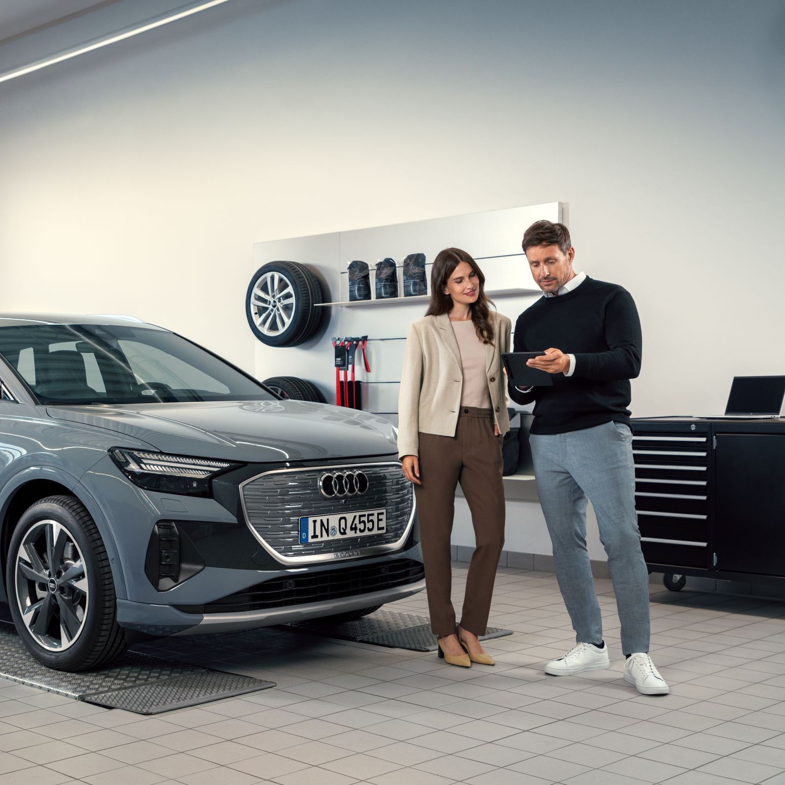 Serviceberater mit Kunde vor dem Q4 e-tron in der Direktannahme