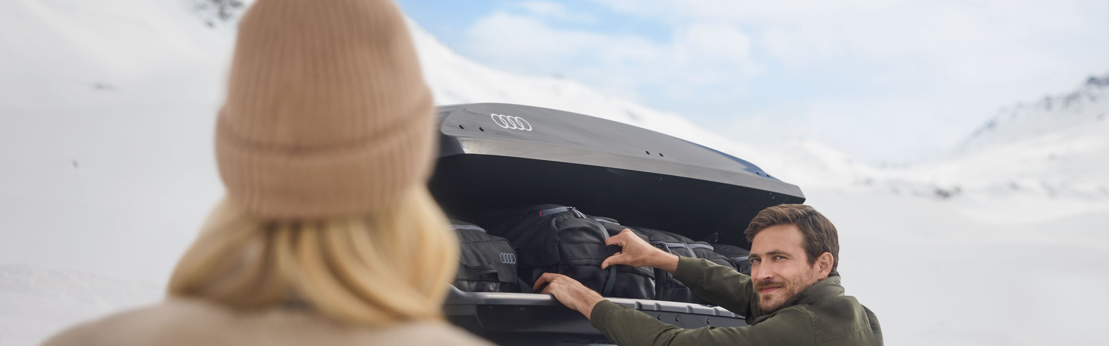 Ein Mann öffnet eine Dachbox auf einem Audi S6