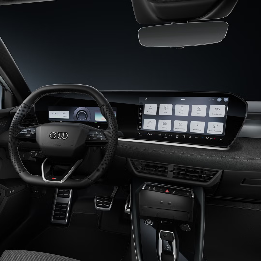 Blick auf das Cockpit mit Fokus auf das Sportlederlenkrad und das geschwungene Panoramadisplay.