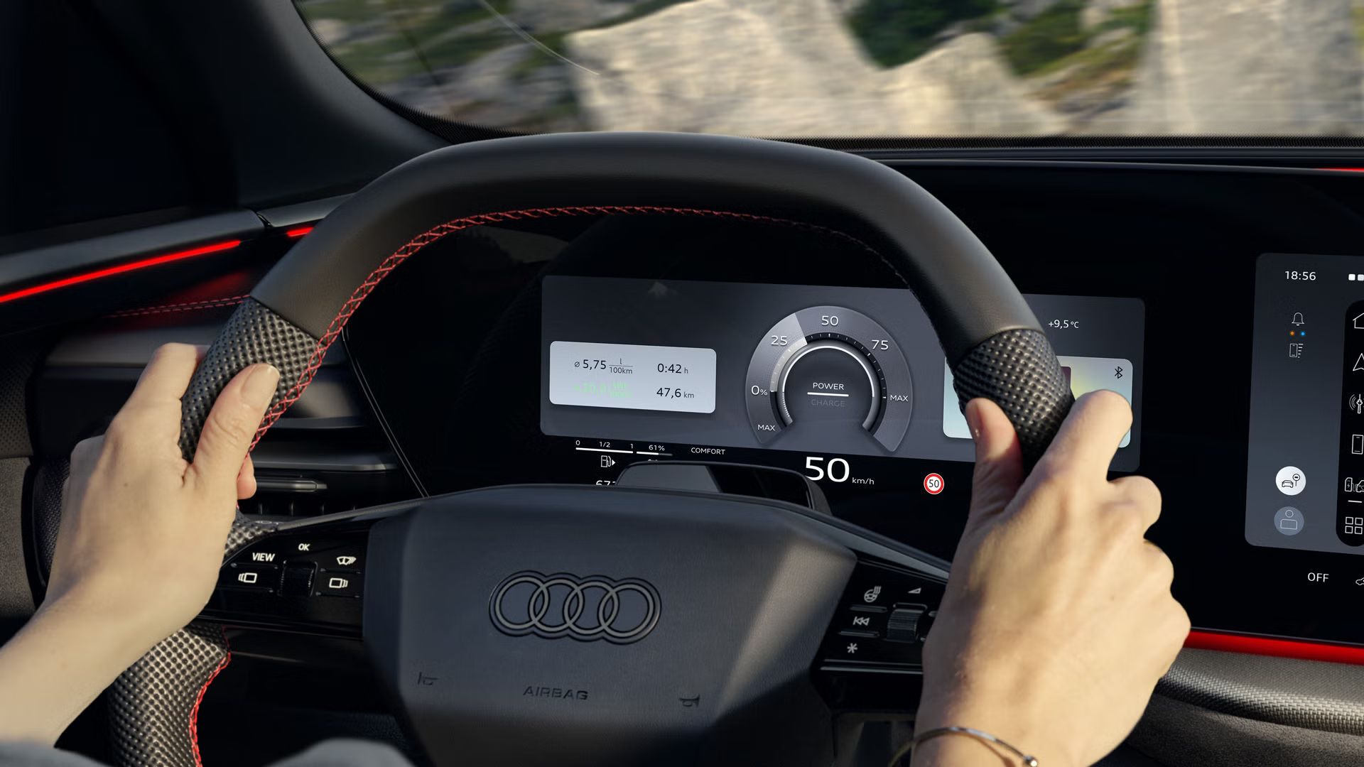 Blick von der Rückbank in das Cockpit des Q5 SUV e-hybrid. Eine Frau sitzt am Steuer und fährt eine Gebirgsstraße entlang. Hinter dem Lenkrad ist das Audi virtual cockpit plus zu sehen.