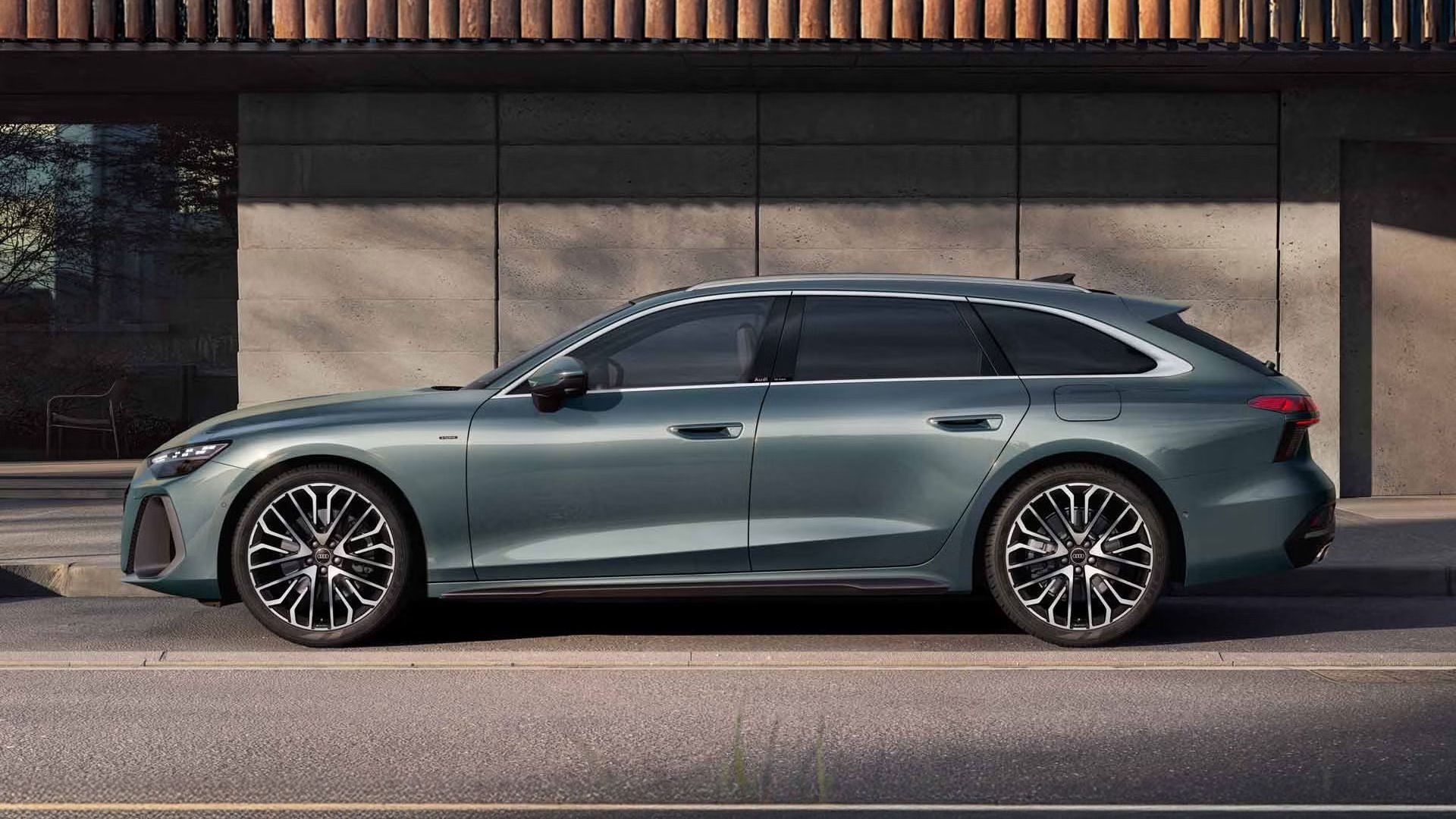 Der A6 Avant e-hybrid in Morgentaugrün steht im Seitenprofil vor der Fassade eines Gebäudes.