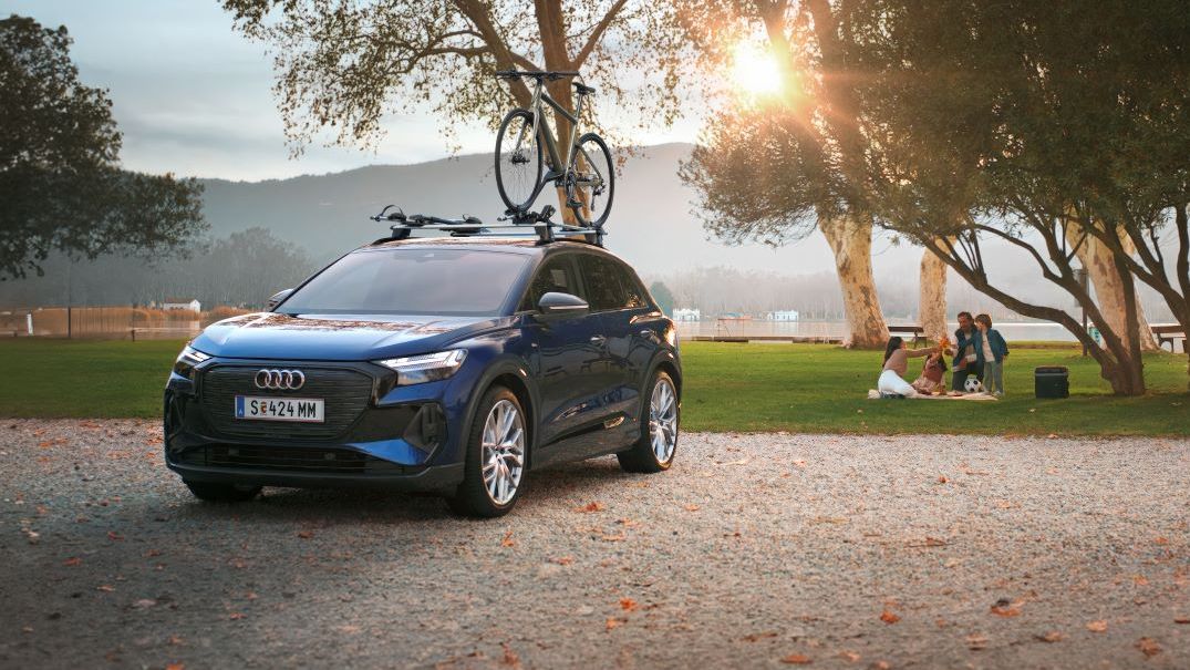 Ein blauer Audi mit Fahrradträger und Fahrrad auf dem Dach.