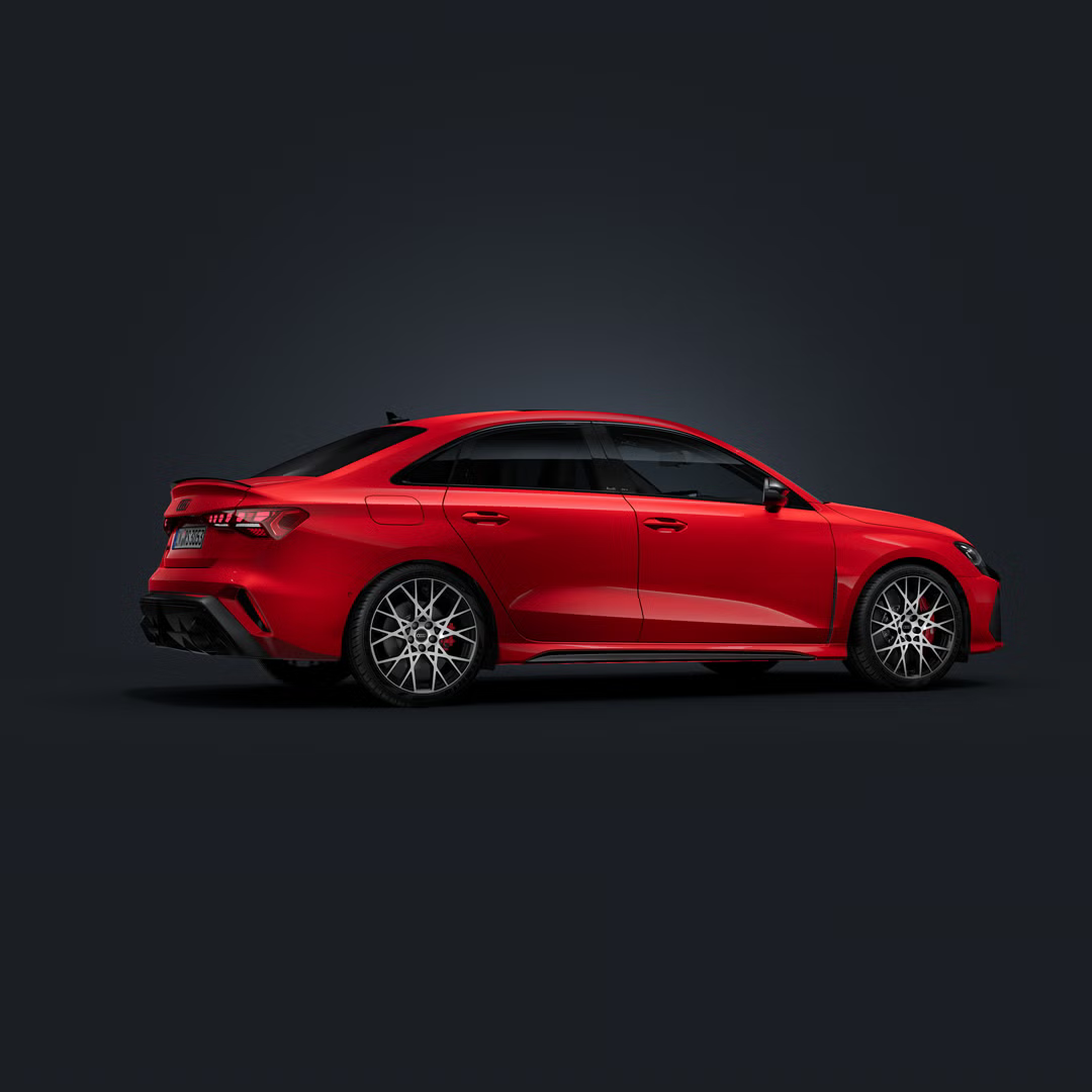 Die Audi RS 3 Limousine steht auf dunklem Hintergrund und dreht sich leicht auf die rechte Seite.