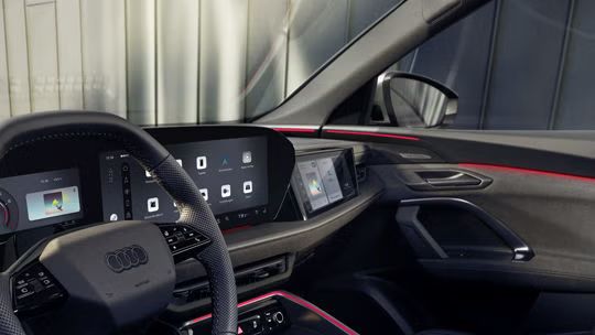 Blick in das Cockpit des SQ5 Sportback durch das Fahrerfenster. Zu sehen sind die verschiedenen Displays im Cockpit, sowie die rote Ambiente Beleuchtung.