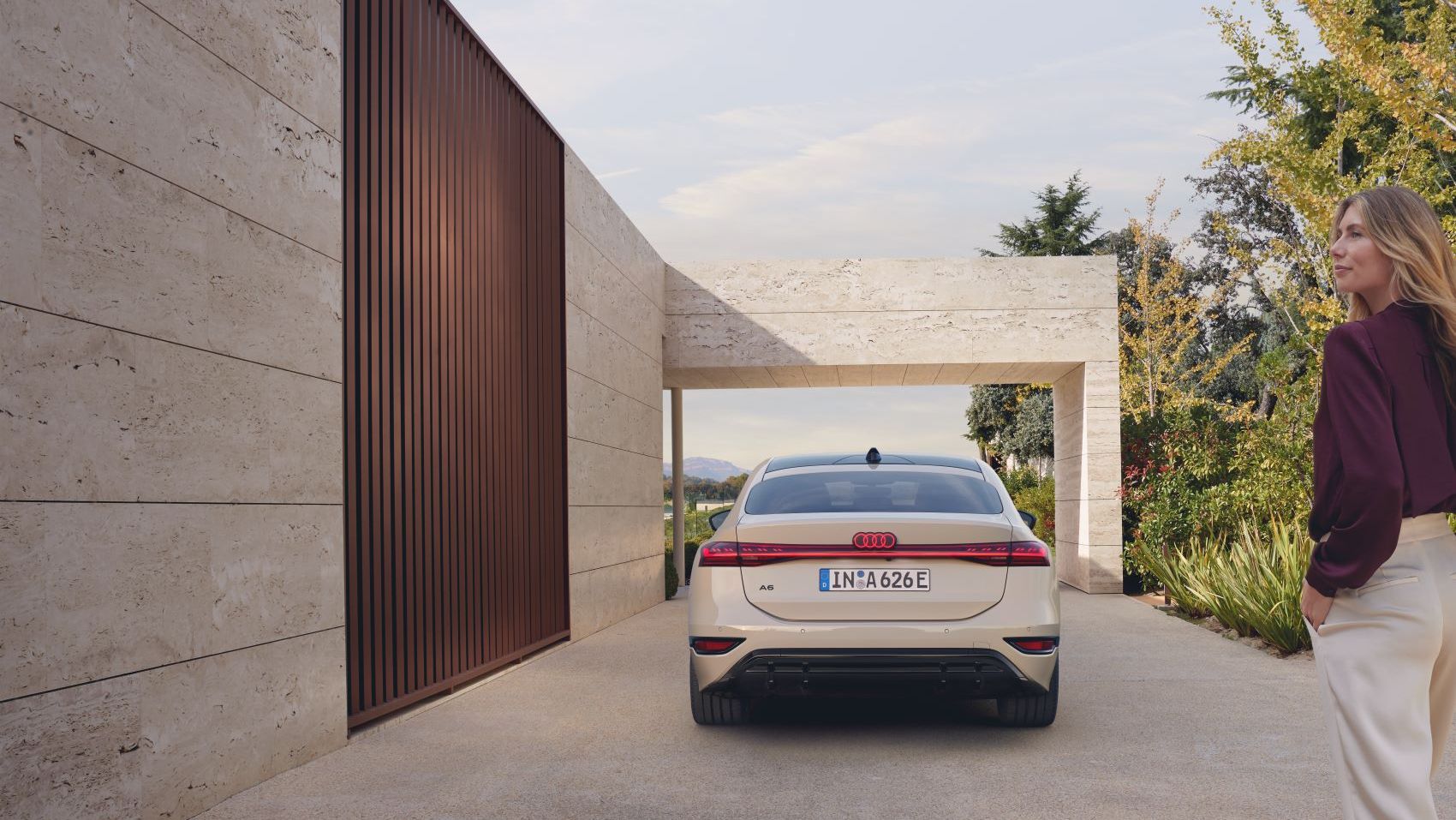 Ein weißer Audi A6 in Heckansicht parkt vor einem Haus.